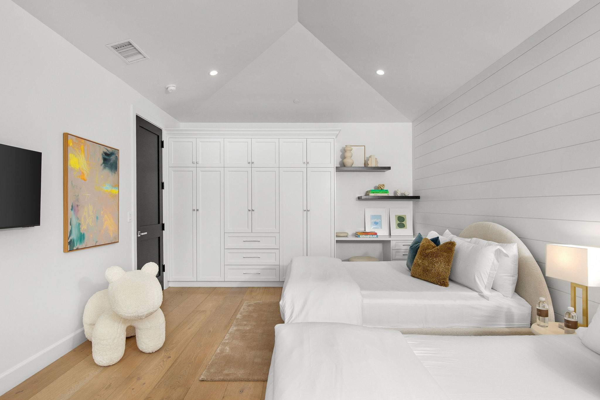 A flexible bedroom designed for guests or family stays, with a clean modern farmhouse aesthetic and built-in storage