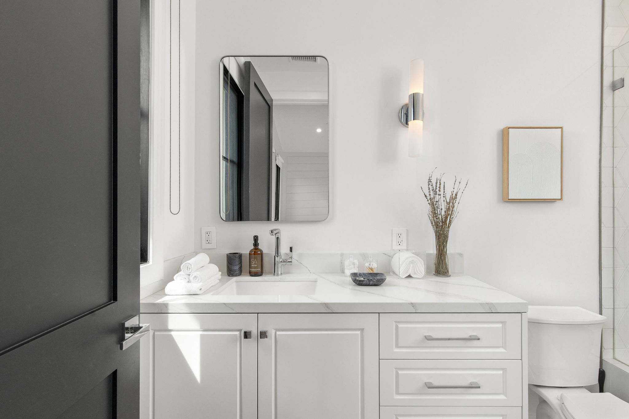 A modern bathroom with custom vanity, stone surfaces, and clean, high-end finishes