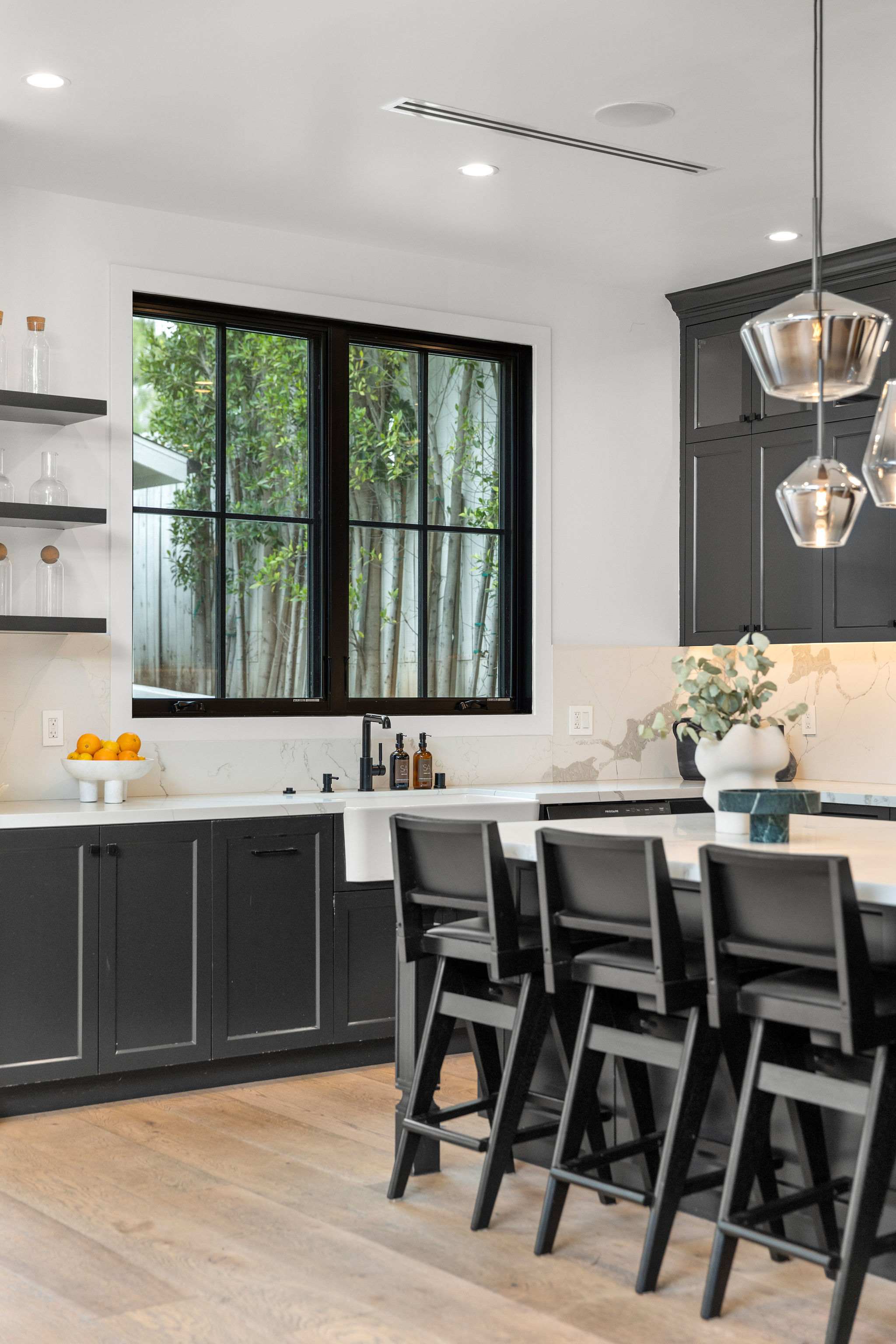 A bright open kitchen with dining flow, large windows, and refined modern finishes