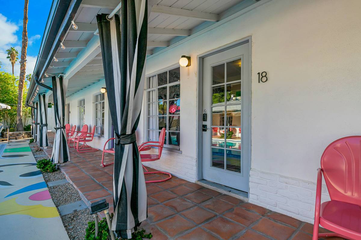 Poolside exterior with striped awnings, colorful chairs and vending machines.