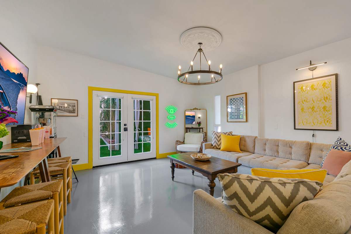 Wide living-room view with sofas, dining furniture and glass doors to the courtyard.