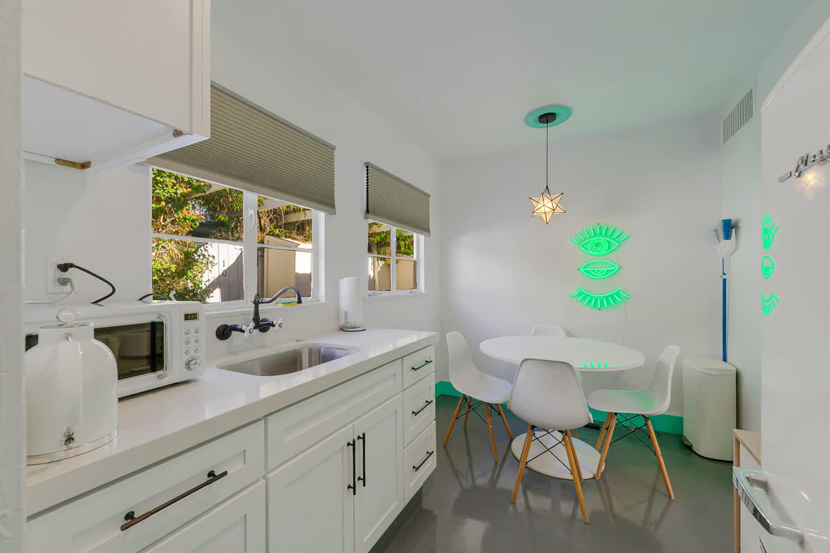 White kitchen and dining nook with a retro-style refrigerator and round table.