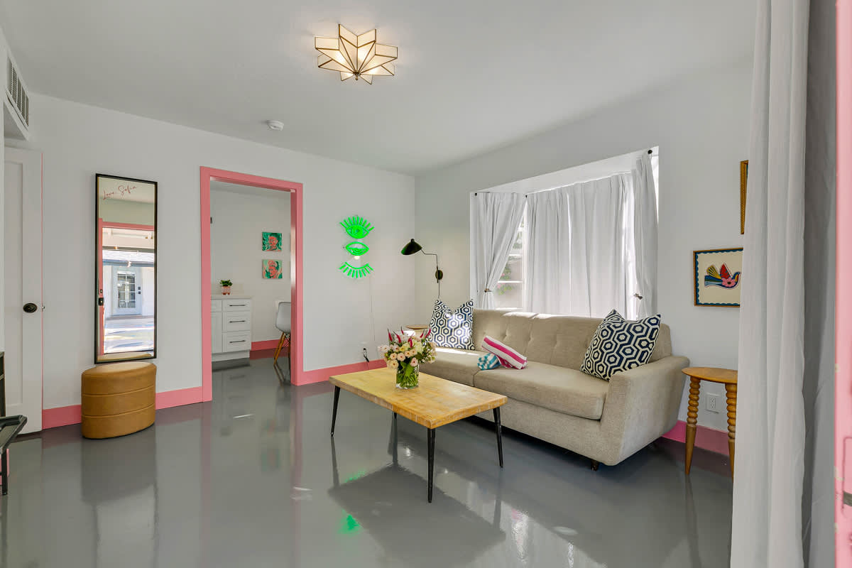 Wide sitting-room view with a sofa, coffee table, television and glass doors.