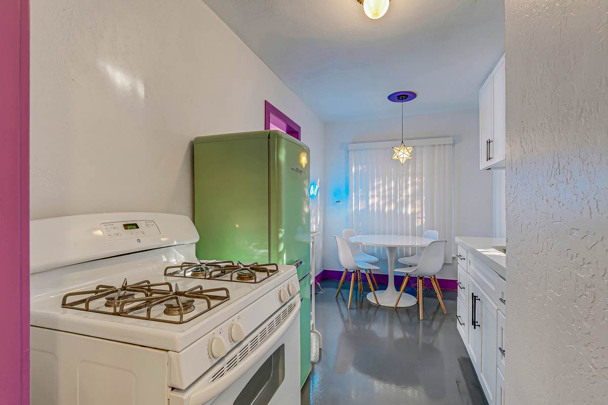 Purple-trimmed kitchen with a retro-style refrigerator, stove and dining nook.