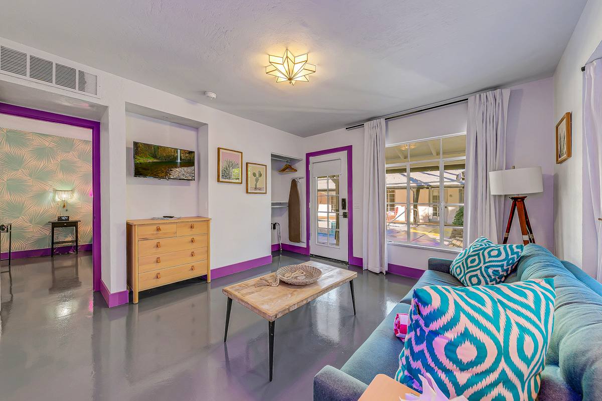 Sitting area with patterned seating, coffee table and glass doors to the courtyard.