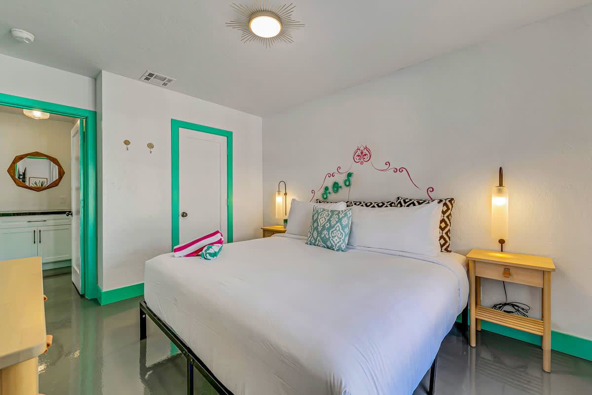 Bedroom with mint-green trim, a bedside lamp and yellow furniture.