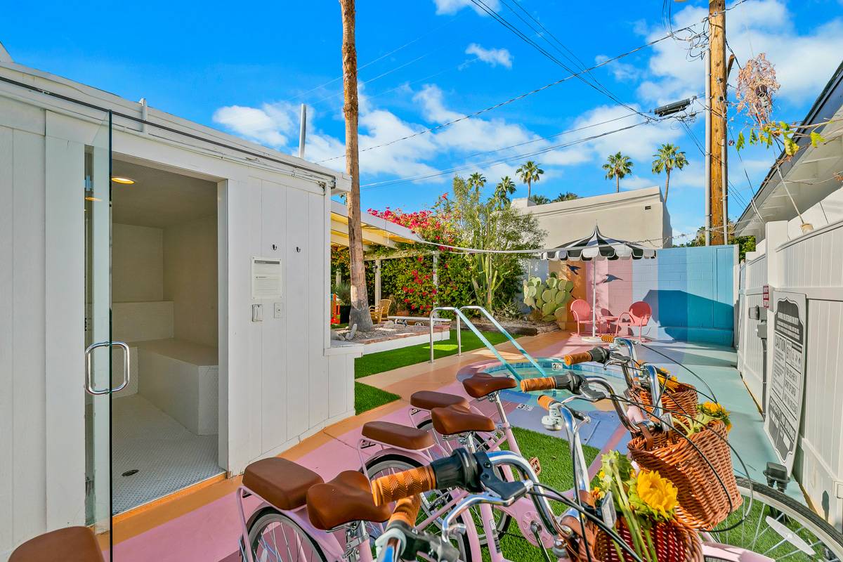 Close view of bicycles beside the white fence and colorful courtyard.