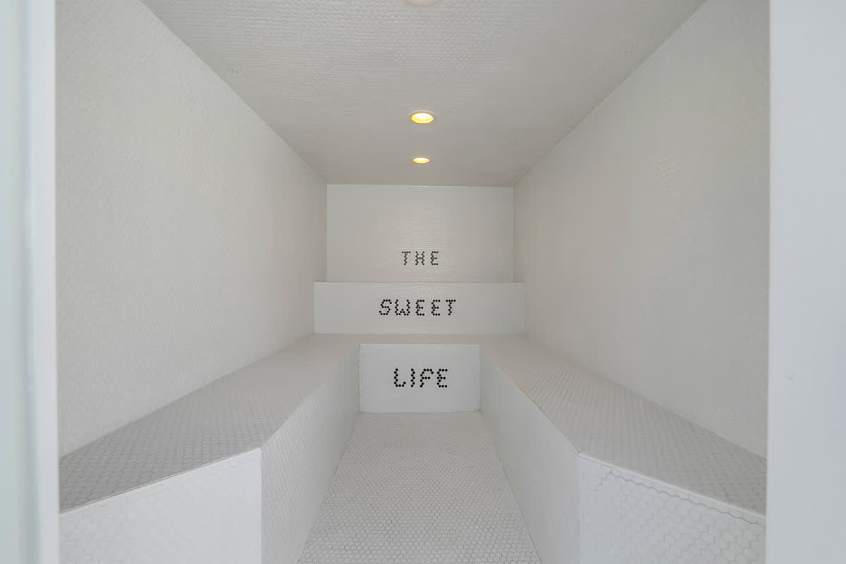 Tiled shower with a decorative word design on the back wall.