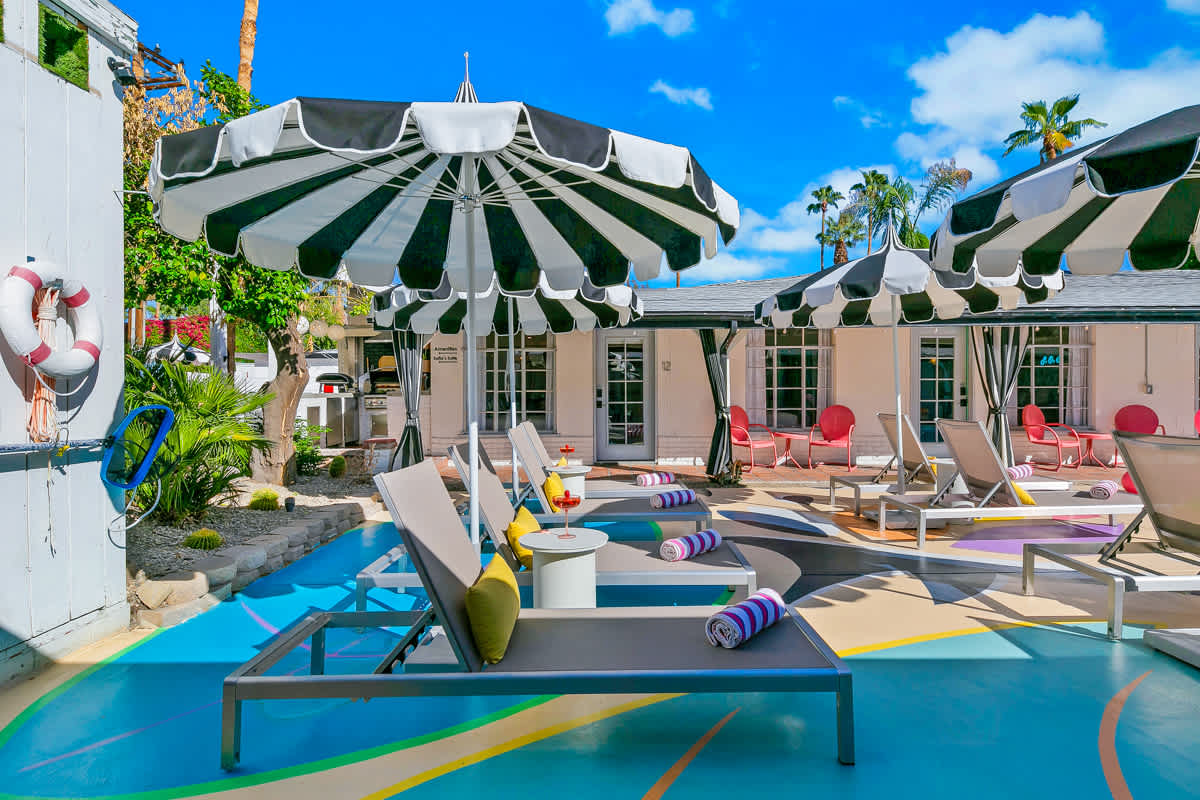 Lounge seating and striped umbrellas beside the courtyard pool.