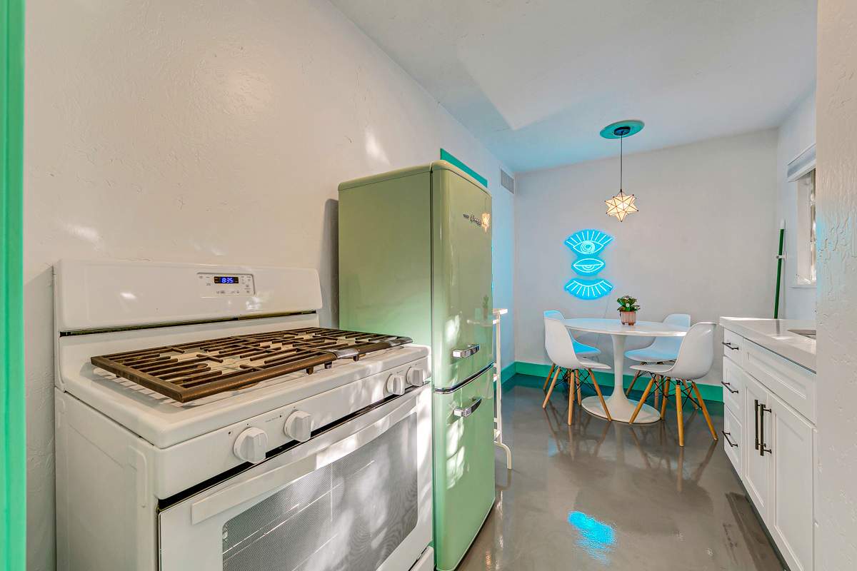 Kitchen with a stove, retro-style refrigerator and small dining area.