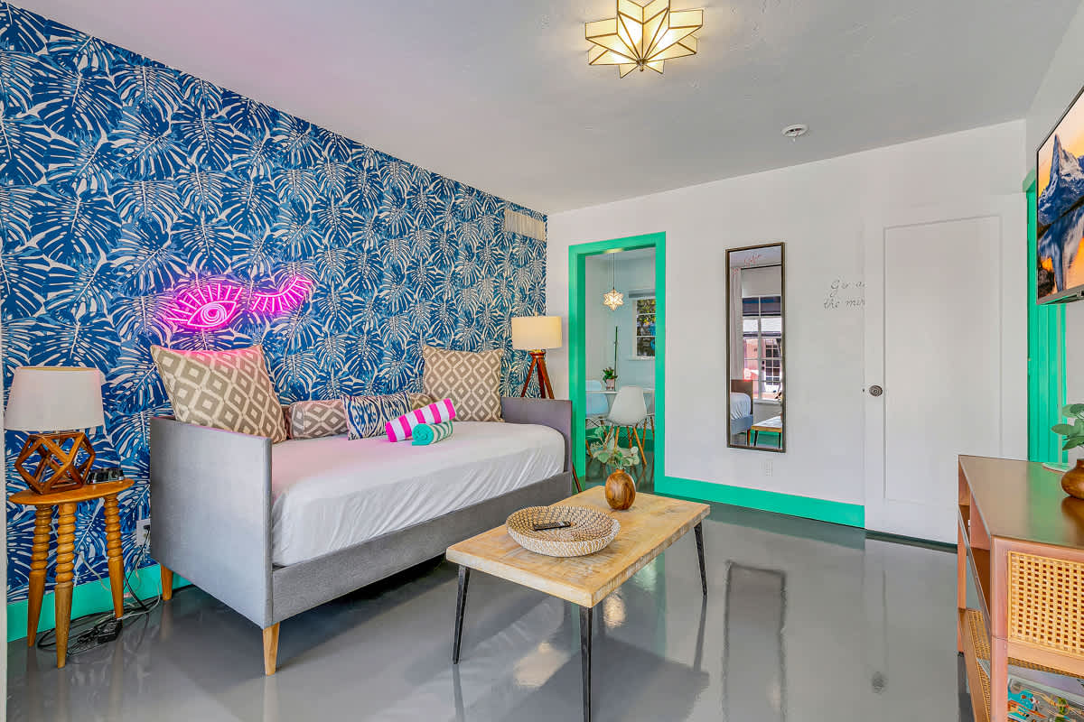 Sofa and coffee table against a blue patterned wall with mint-green trim.