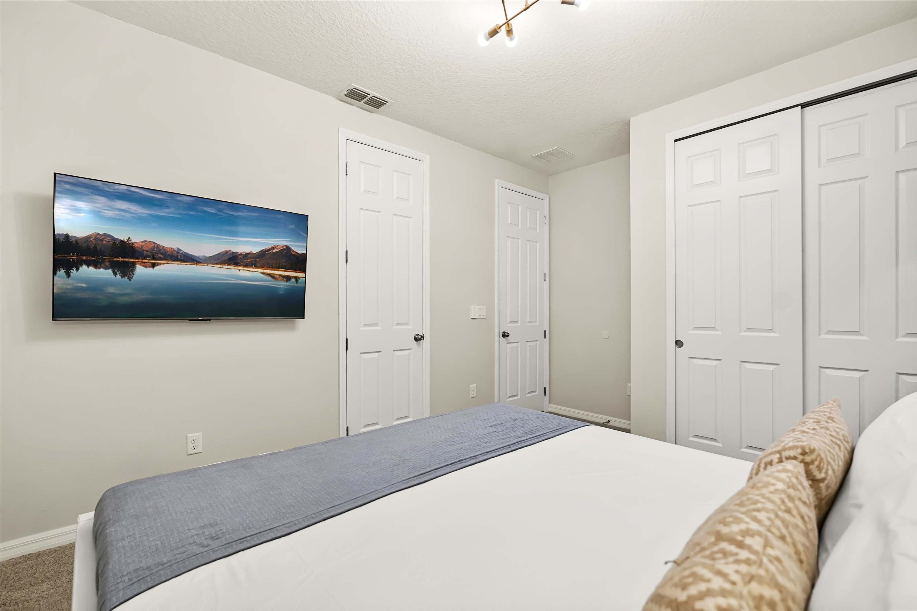 Queen bedroom with Smart TV and storage, ideal for a restful and tidy stay