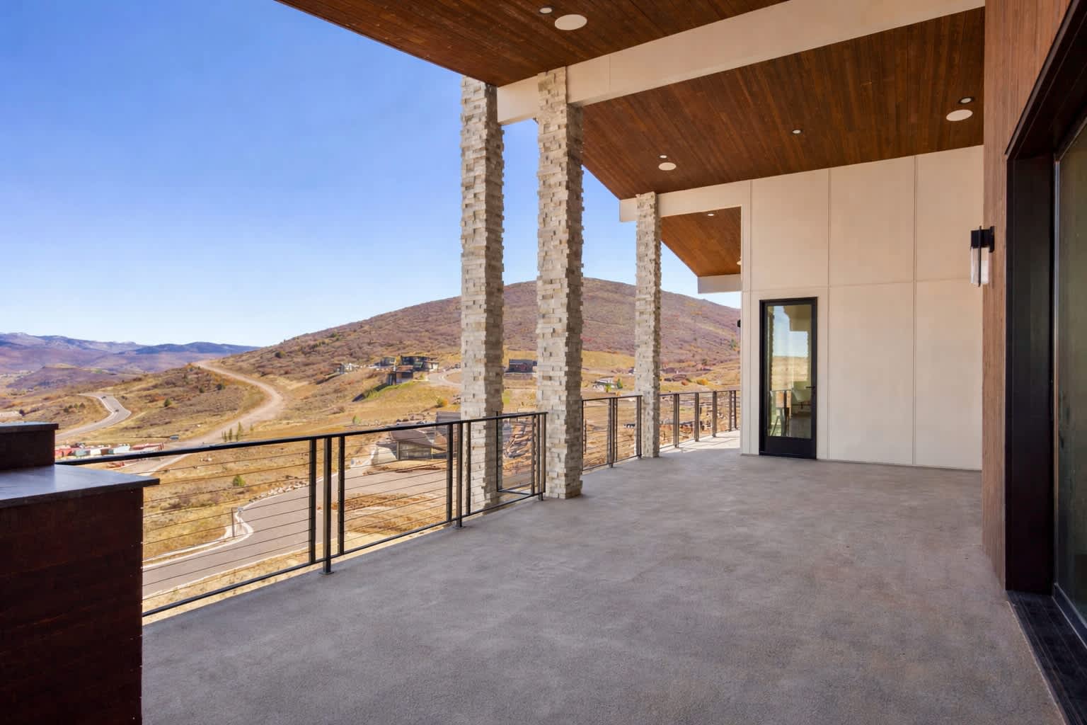 Balcony with outdoor kitchen, firepit, and panoramic views