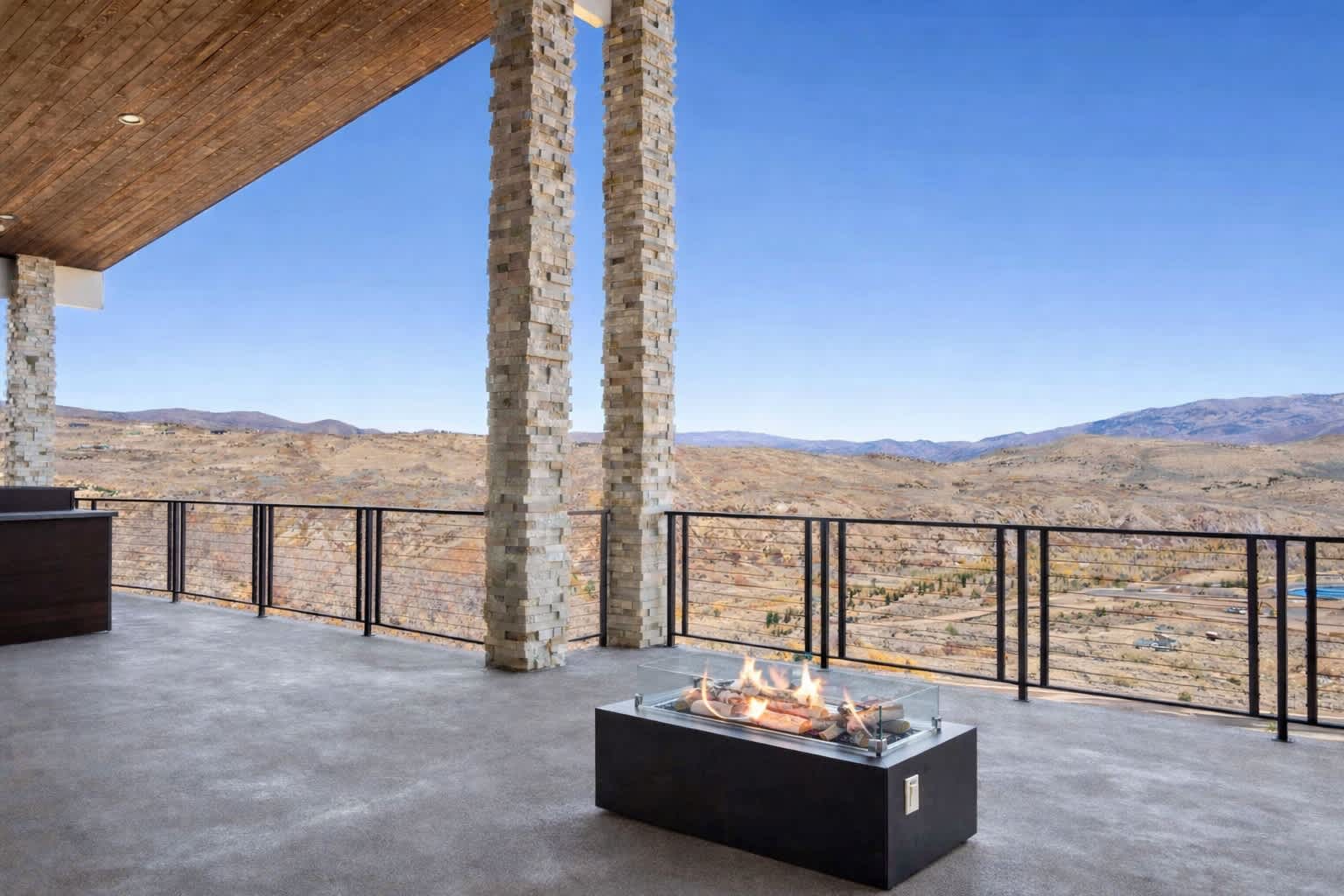 Balcony with outdoor kitchen, firepit, and panoramic views