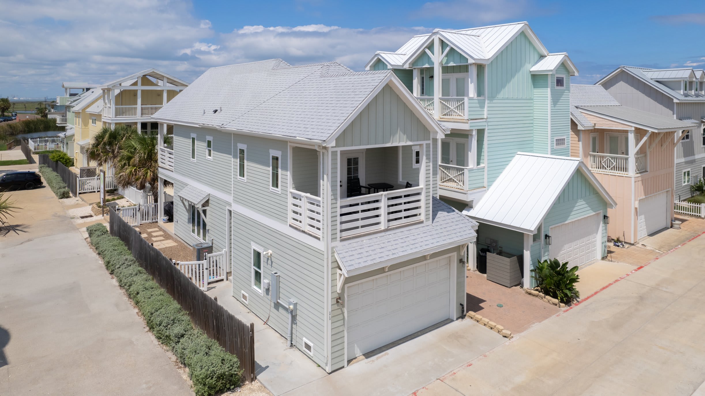 Exterior Aerial — Gray Two-Story with Garage, Covered Balcony & Colorful Neighborhood