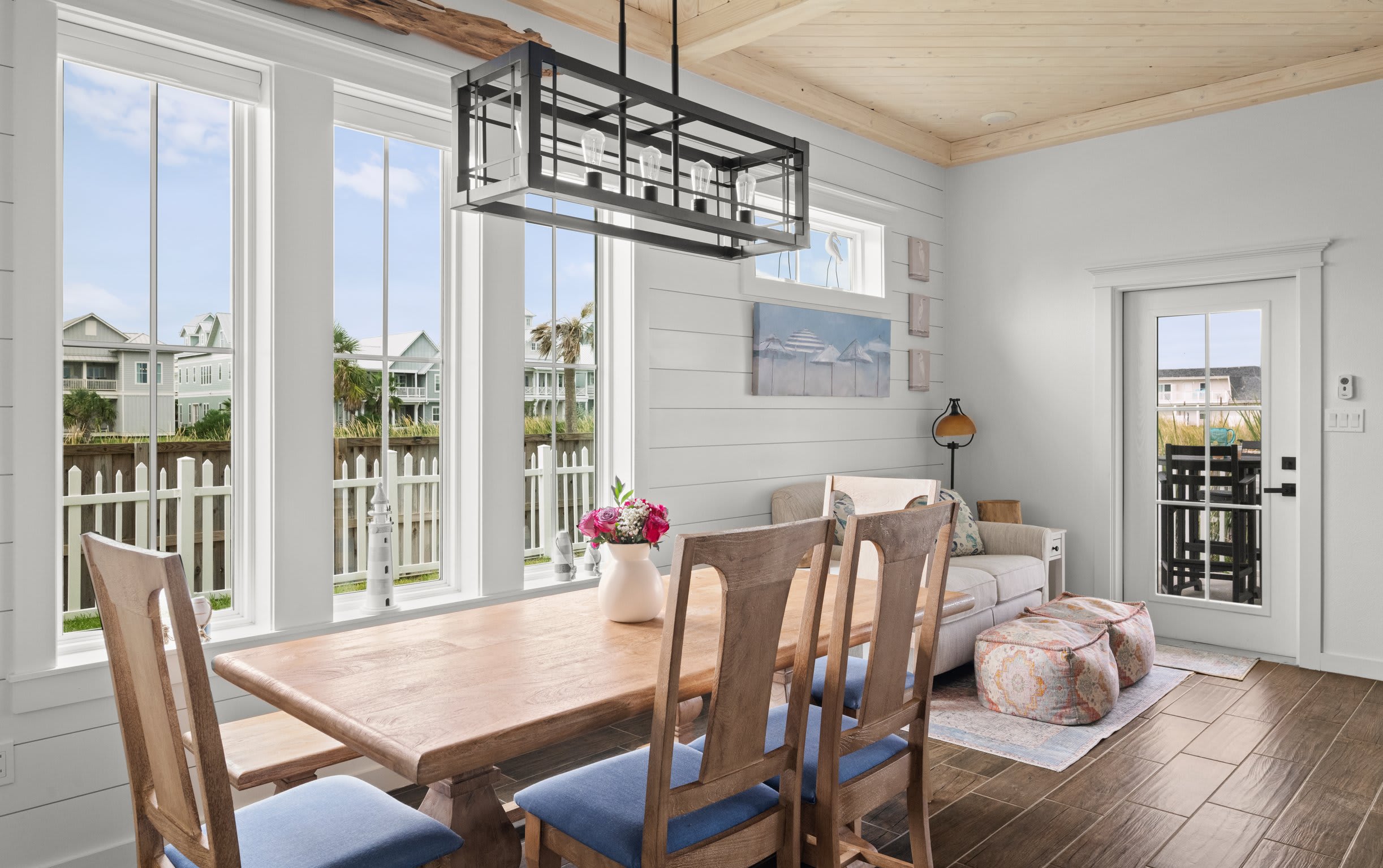 Dining area — alternate angle with large windows, industrial chandelier, and patio door
