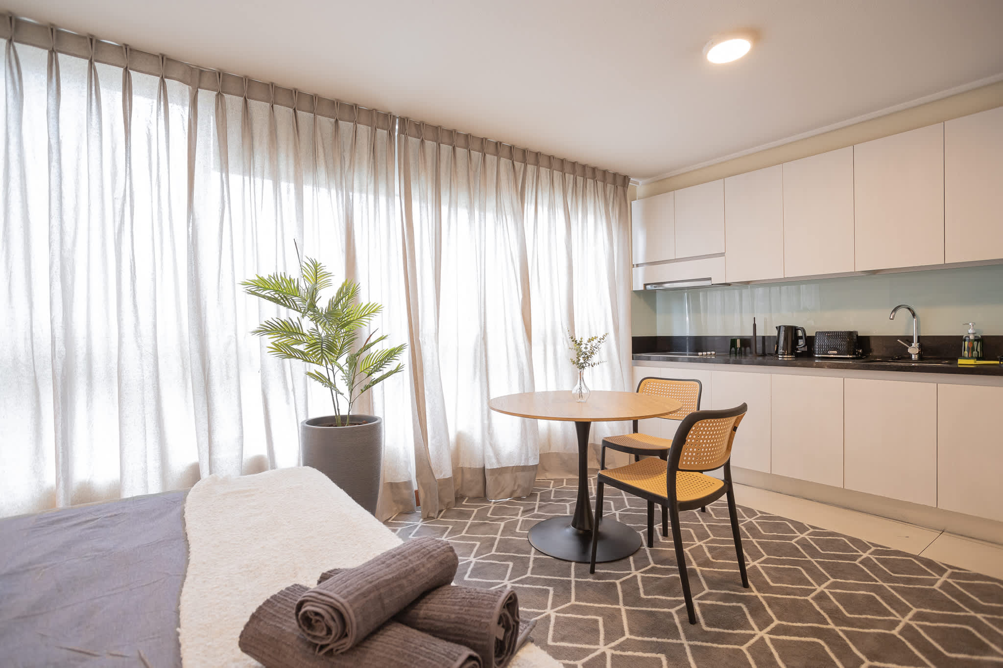 Bright and modern studio with a cozy dining area and sleek kitchenette, perfect for a relaxing stay.