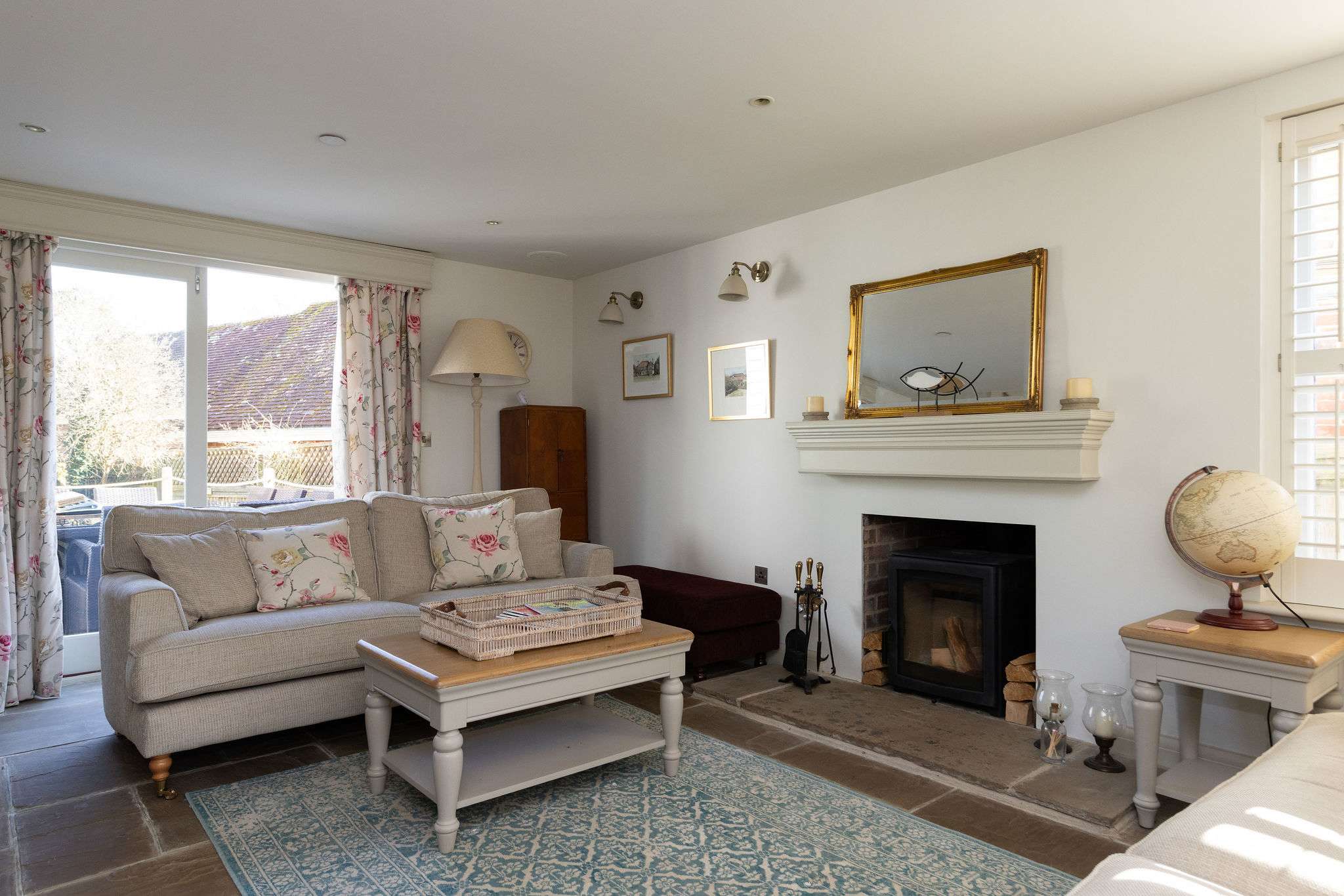 Cosy living room with wood burner and doors opening onto the garden
