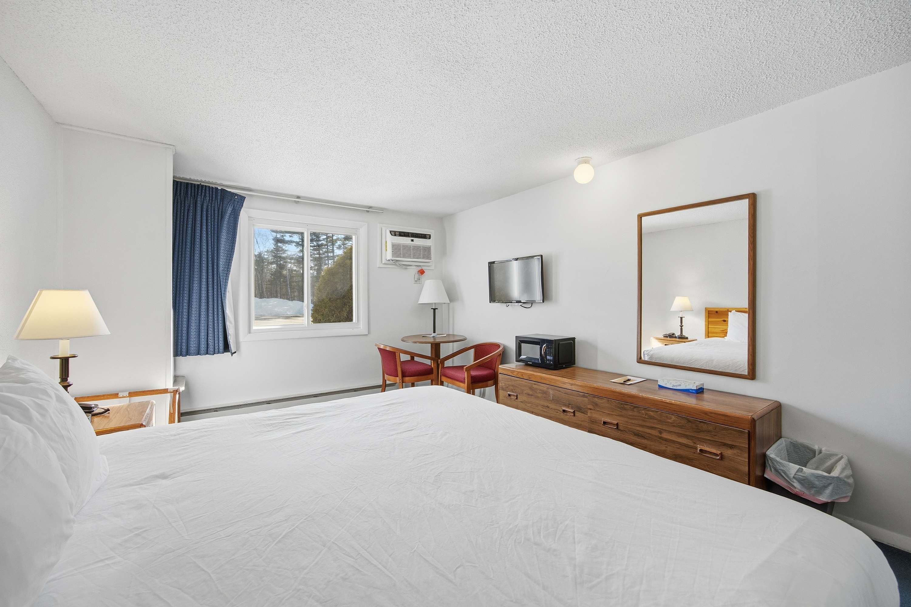 This charming suite boasts a plush king bed, dining area, & TV​