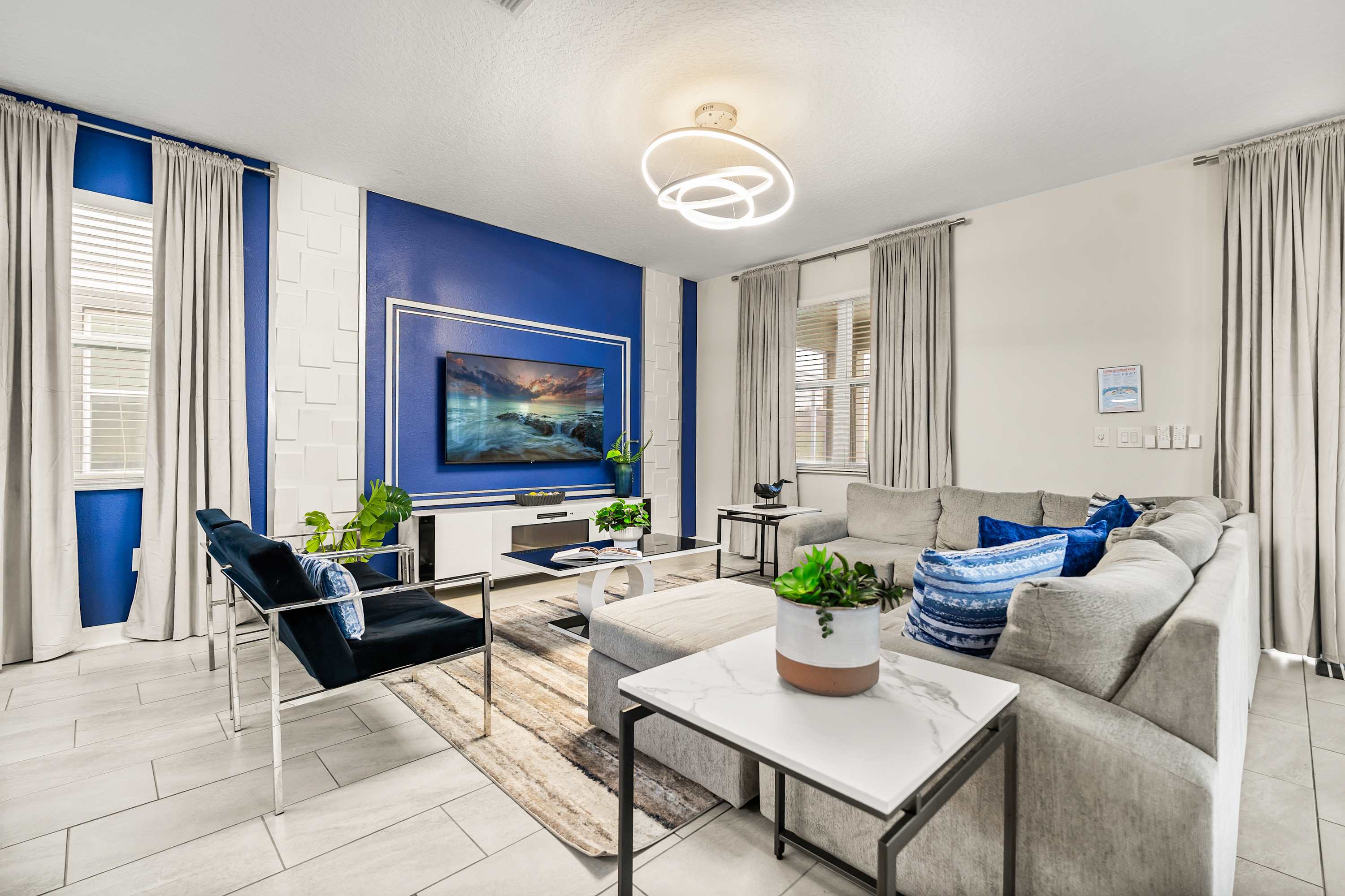 Bright living area with comfortable seating, modern design, and TV for entertainment.