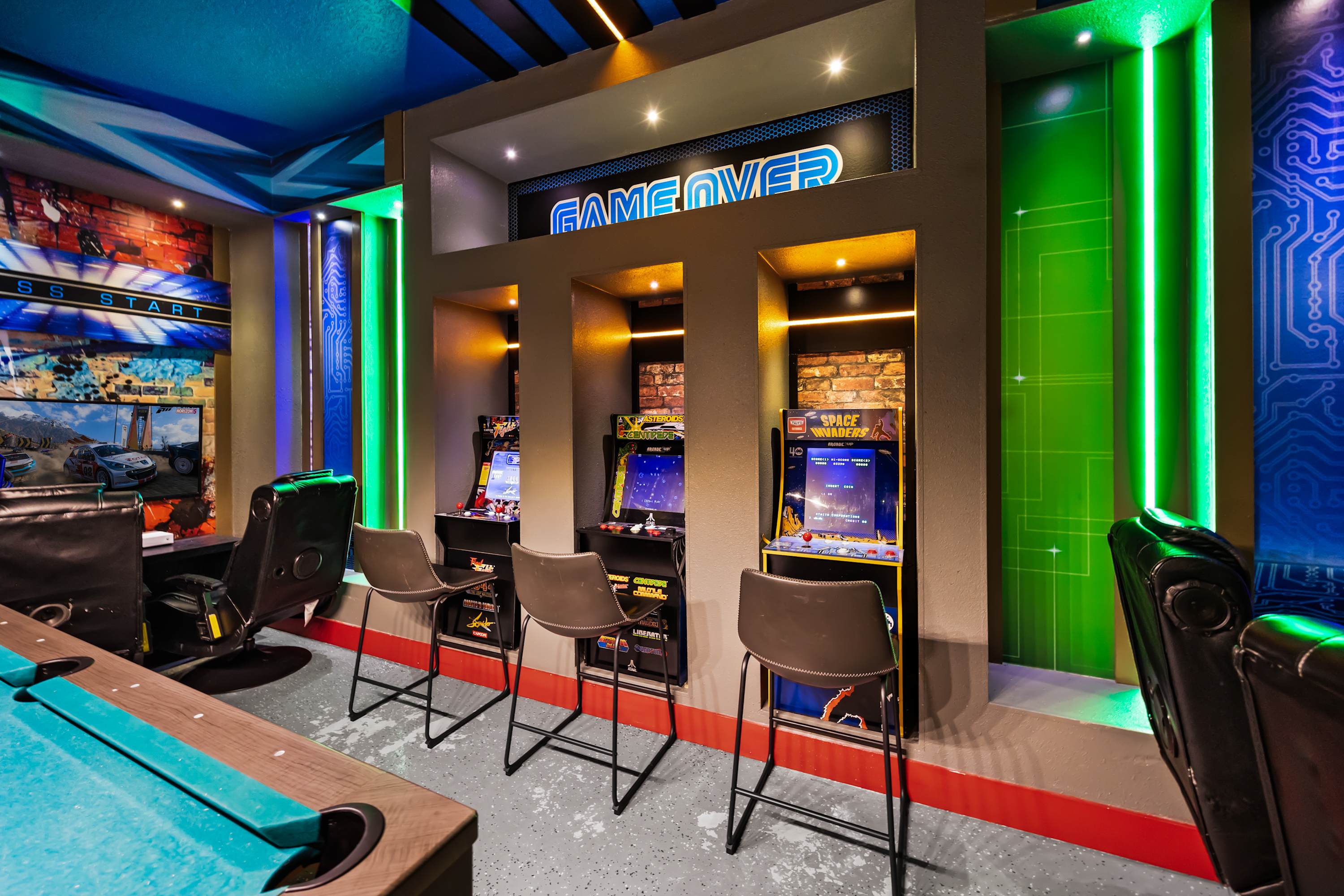 Arcade corner with multiple machines and seating area for a true retro gaming experience.