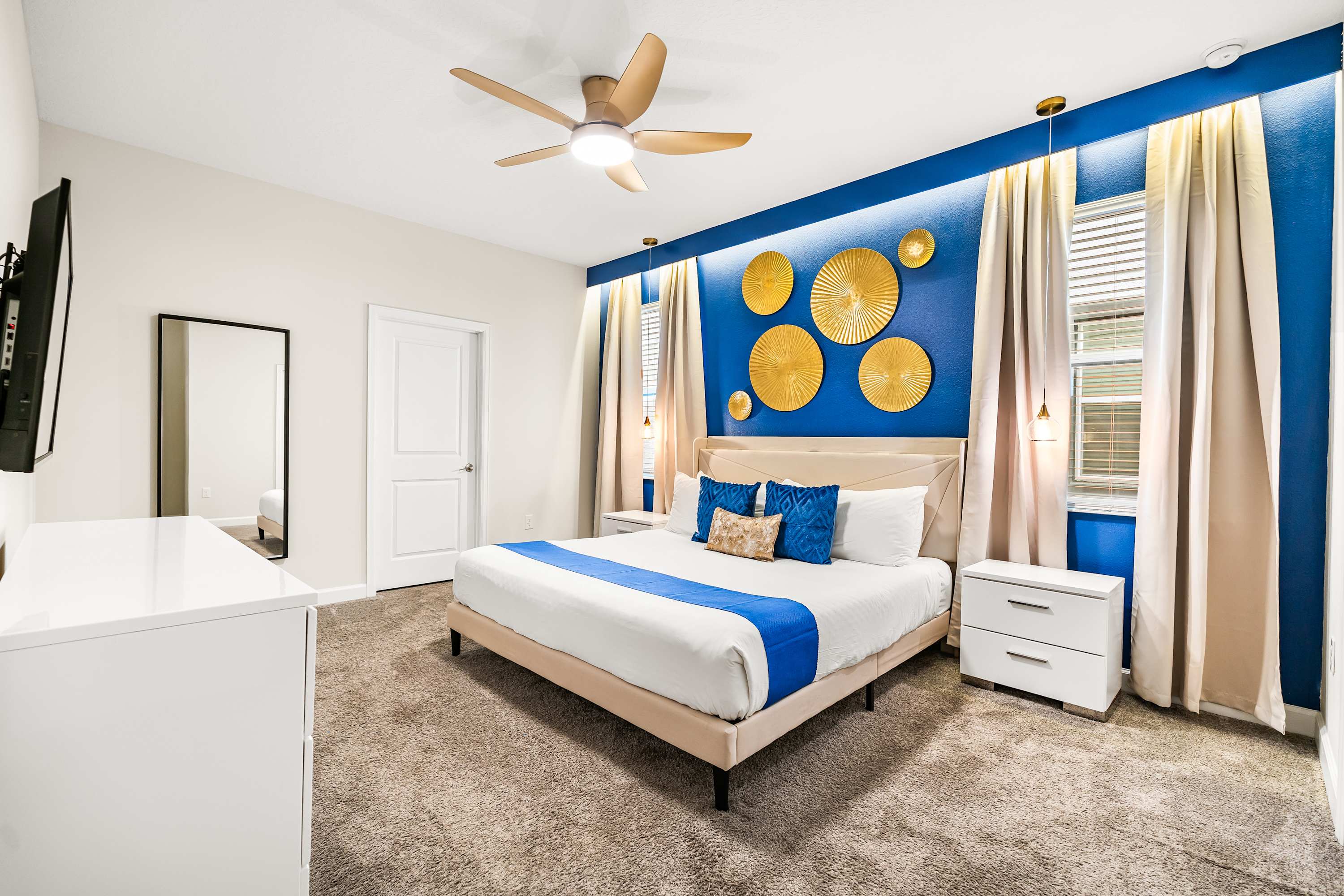 Spacious master bedroom with king bed, statement accent wall, and elegant design details.
