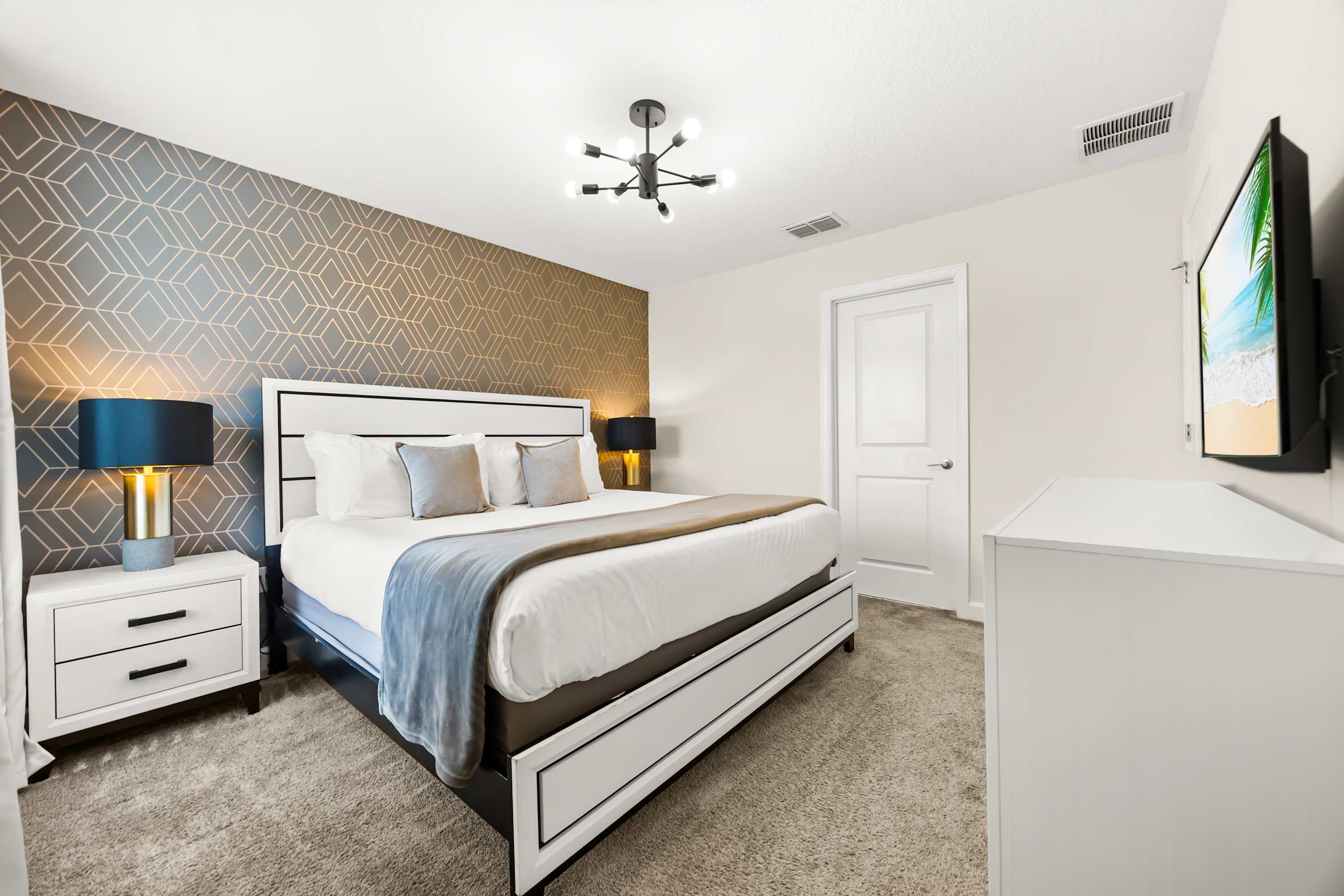 Elegant bedroom with upholstered bed, textured accent wall, and warm lighting.