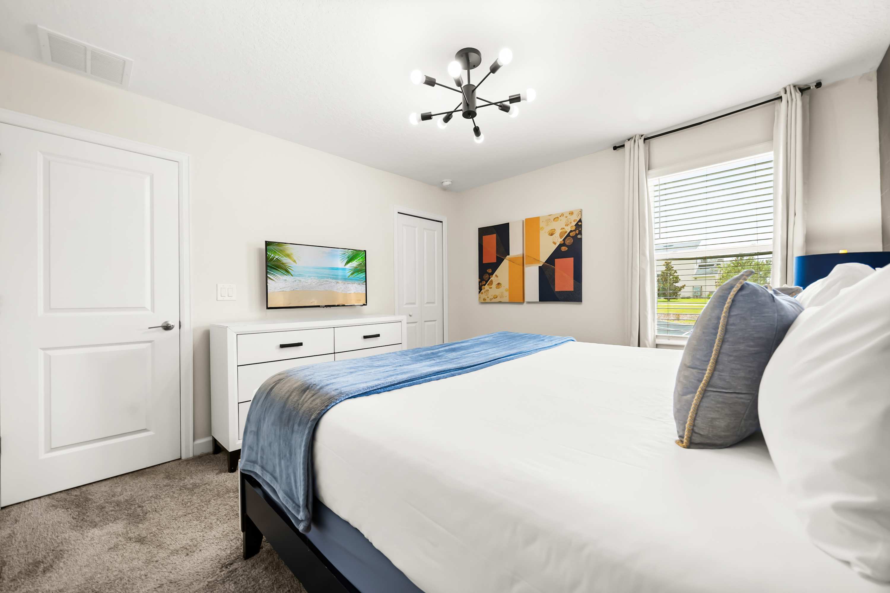 Bright bedroom with natural light, cozy bedding, and a clean, relaxing layout.