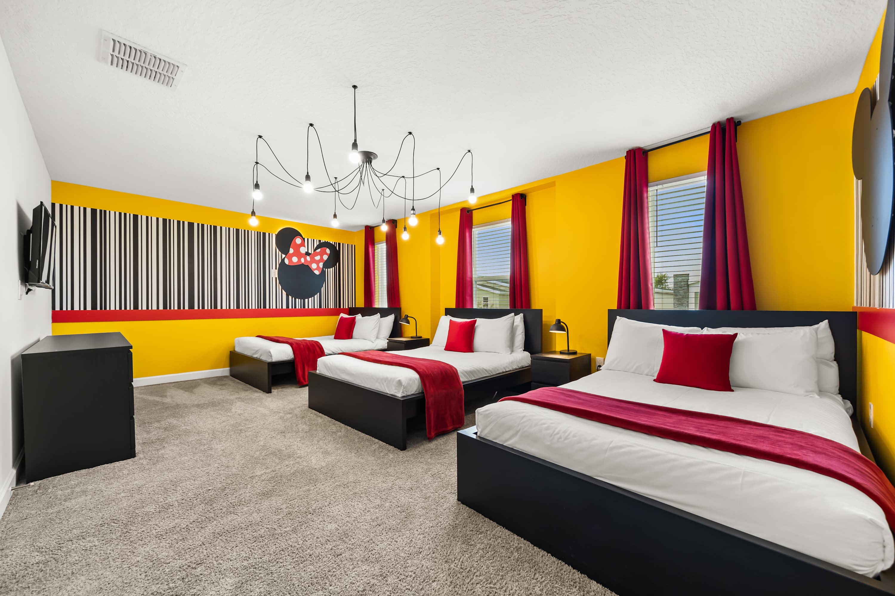 Mickey Mouse-themed bedroom with 3 double beds and smart TV.