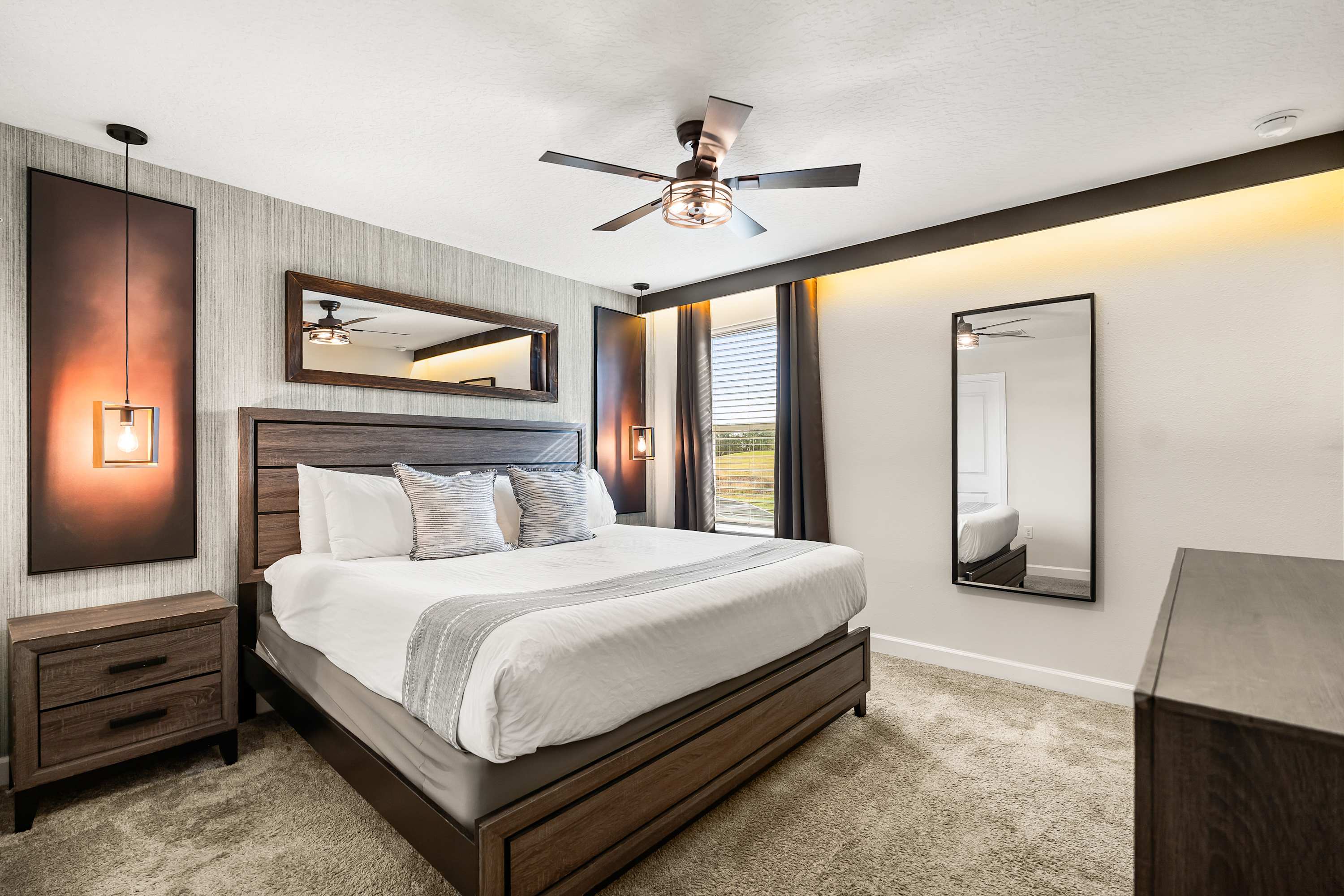 Elegant bedroom with king bed, warm ambient lighting.