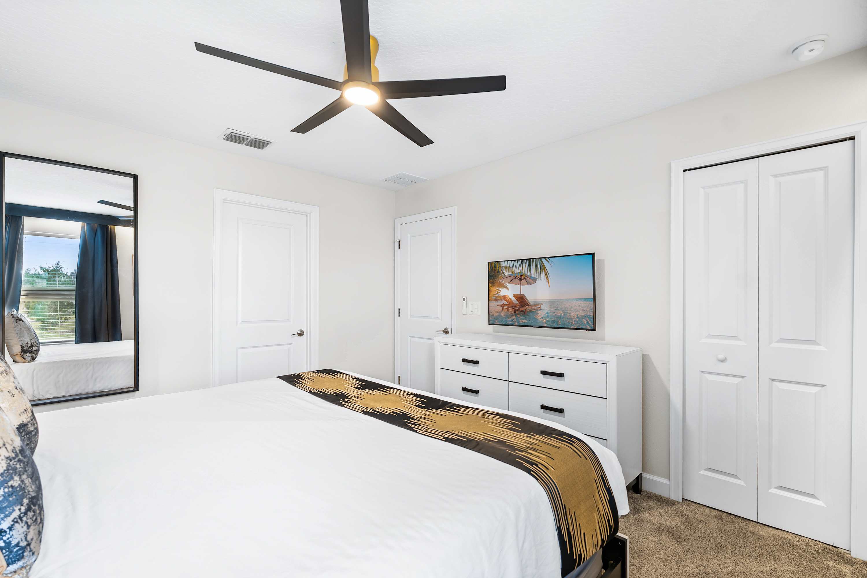 Stylish bedroom with accent wall, king bed, and smart TV for entertainment.