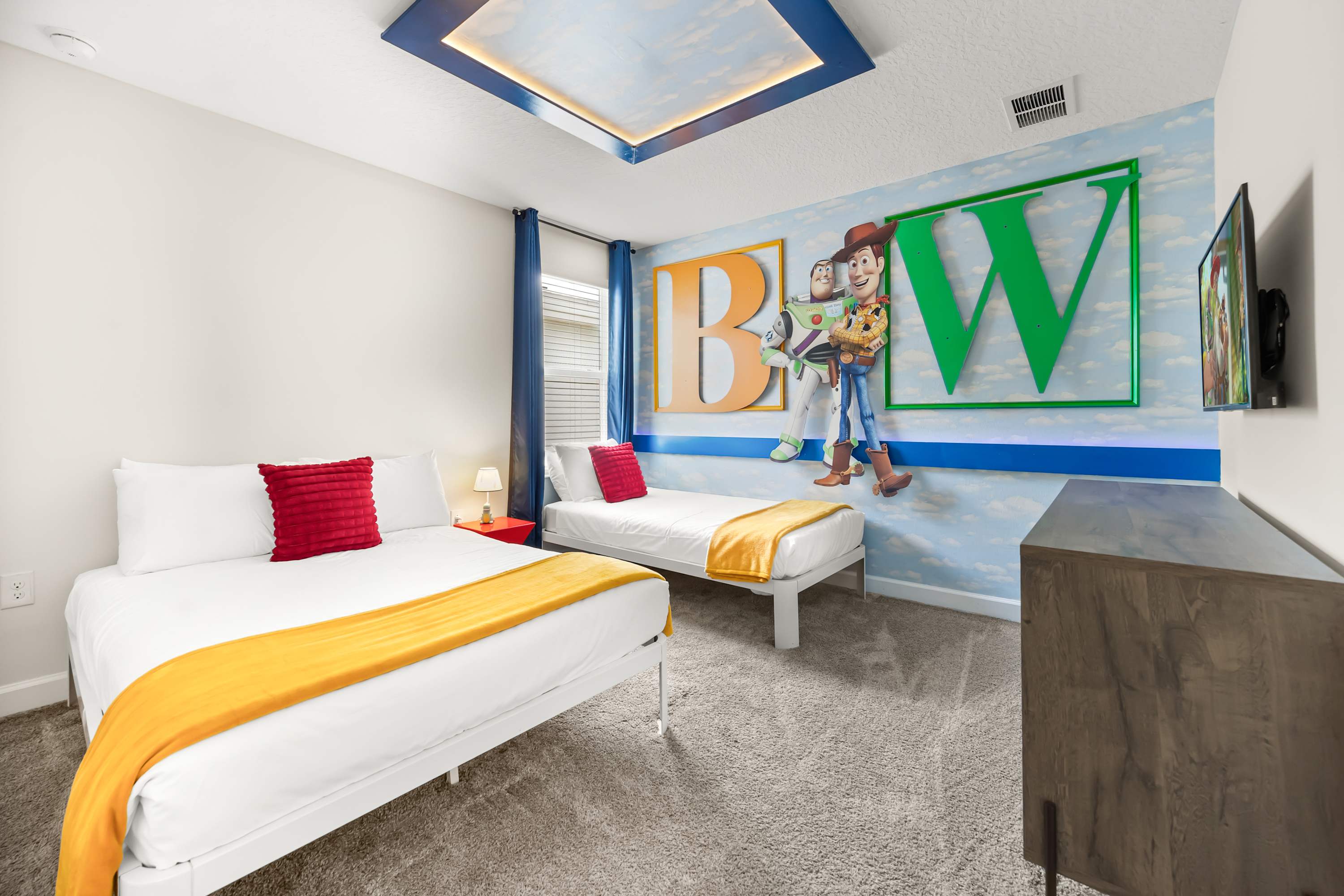 Toy Story-themed bedroom with two beds and colorful wall art, perfect for kids.