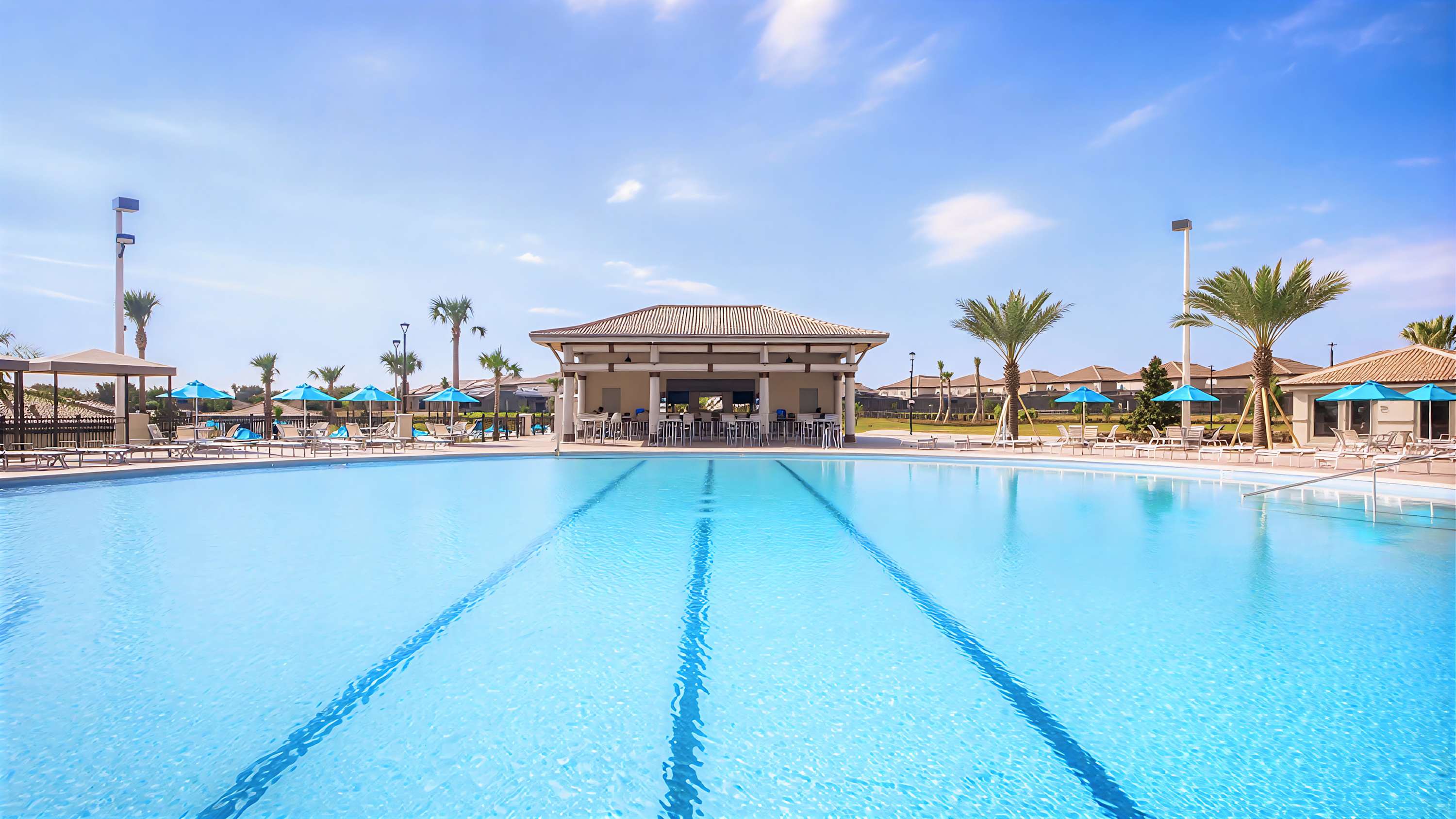 Large resort-style pool with lounge areas and clubhouse nearby.