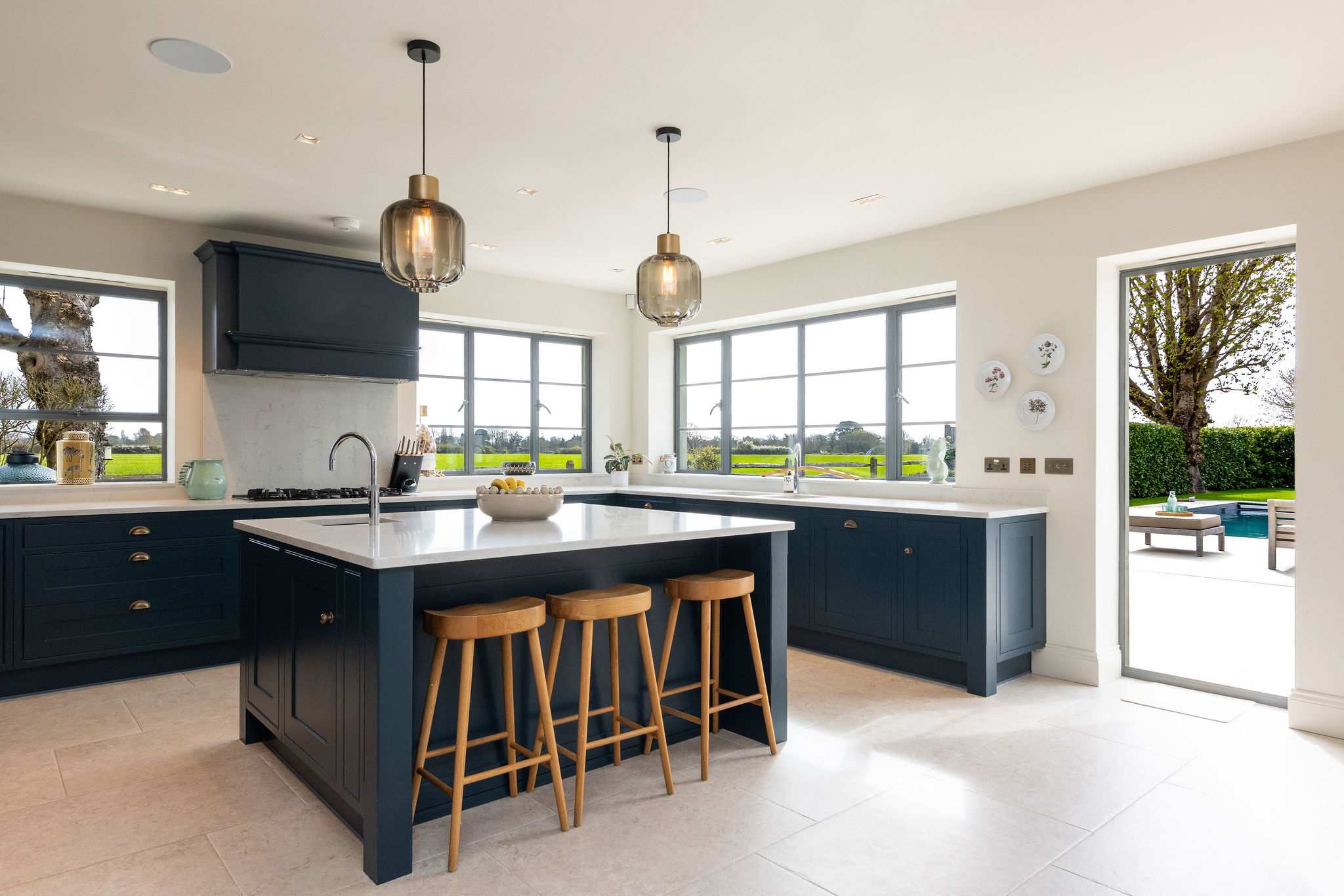 Modern kitchen with large central island, high-spec appliances, and beautiful countryside views throughout.