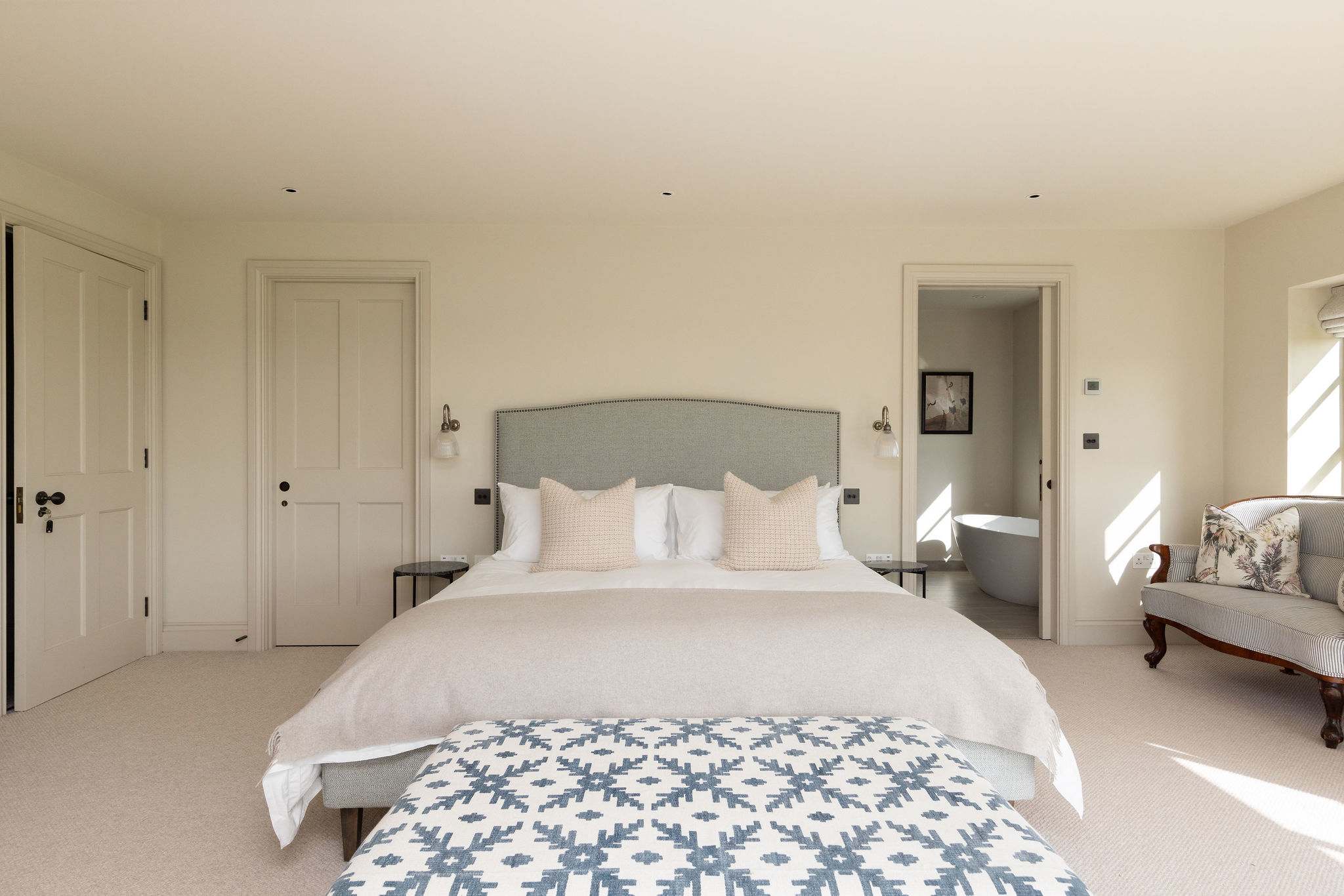 Spacious king bedroom with ensuite access, luxurious linens, and a calm, relaxing atmosphere.