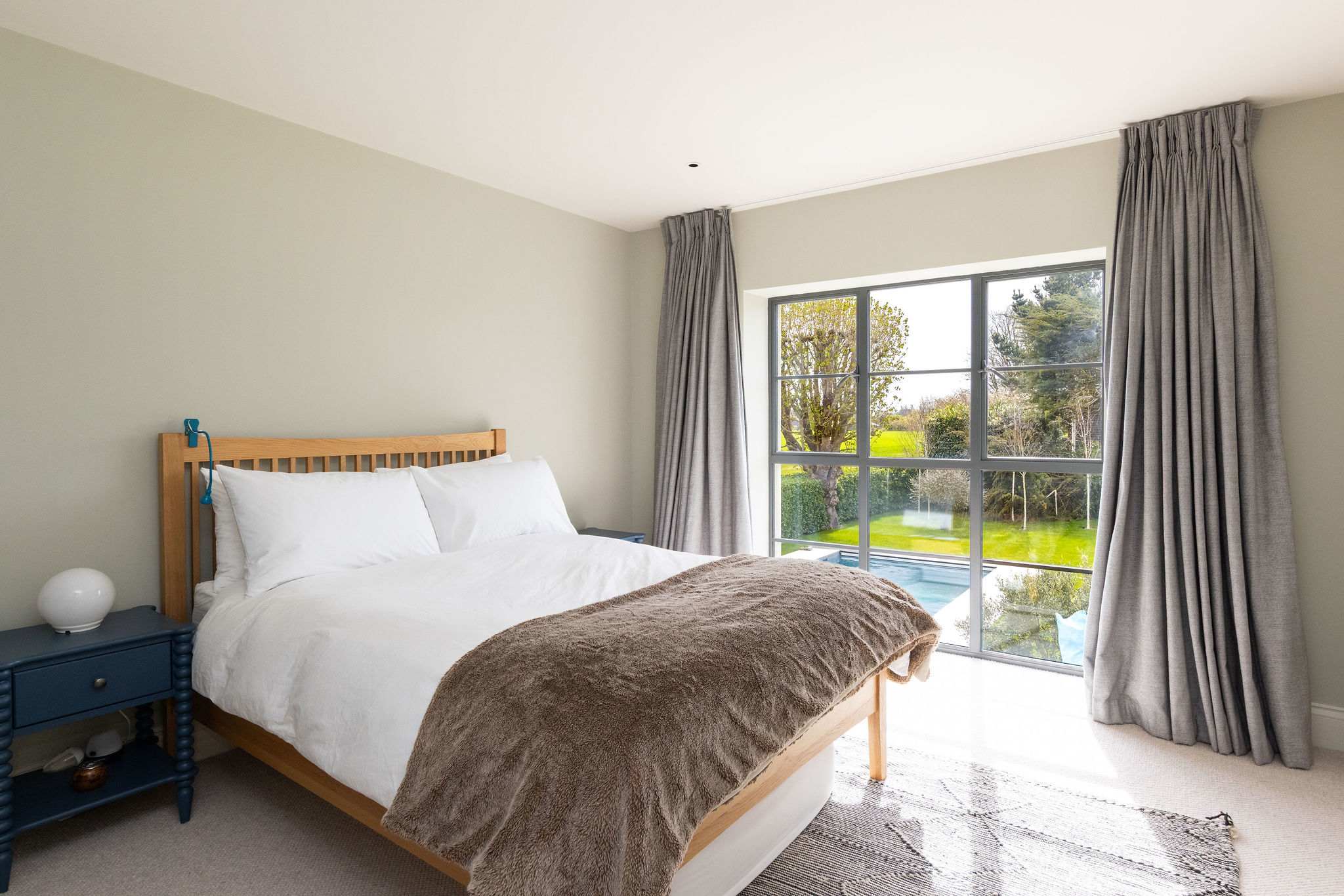 Stylish double bedroom with garden access, cosy textures, and a calm, contemporary feel.