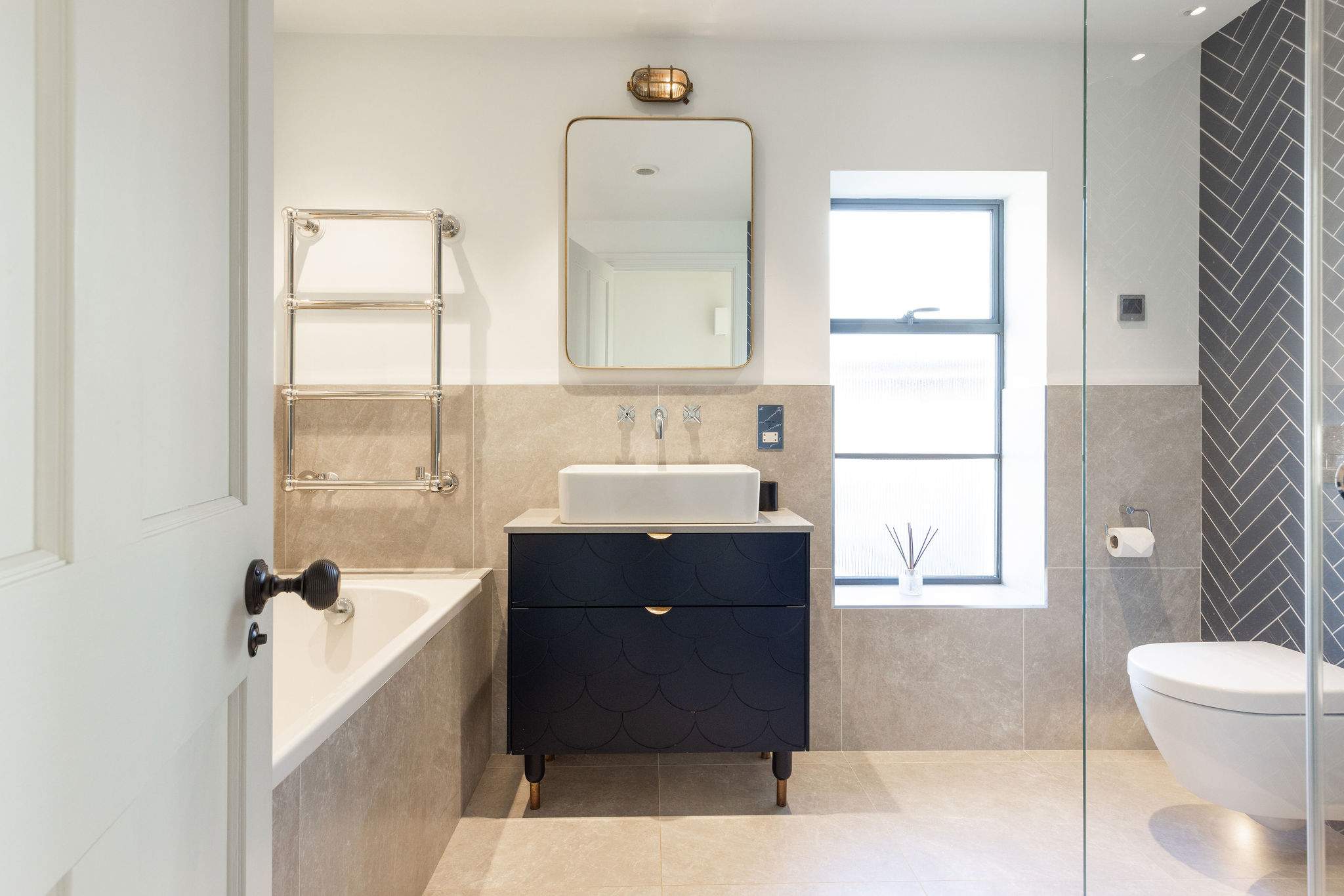 Spacious family bathroom with bath, walk-in shower, and stylish contemporary fittings throughout.
