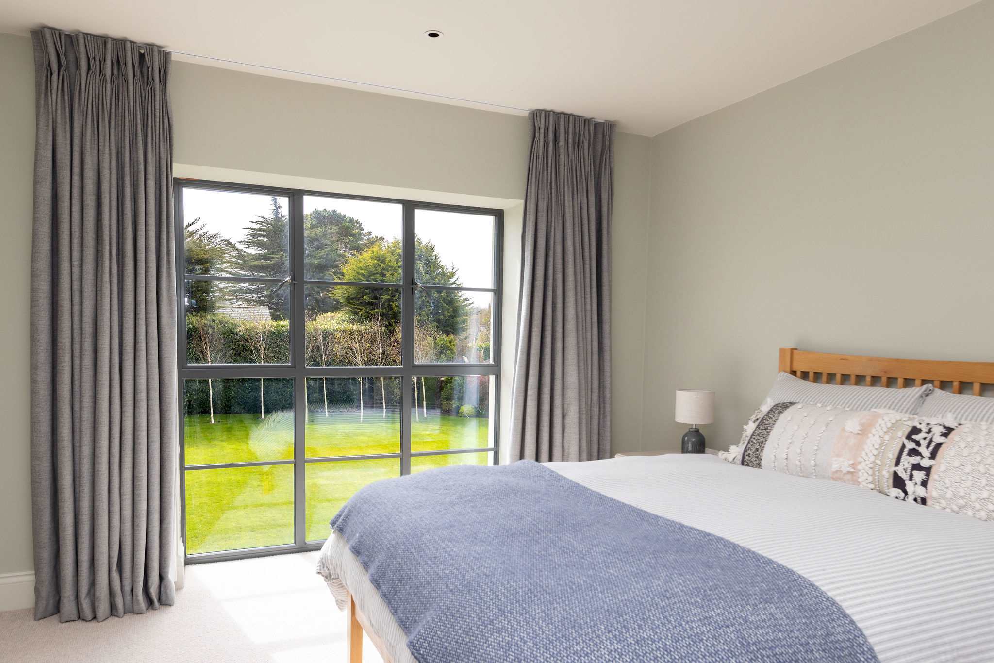 Bright double bedroom overlooking the lush green garden, perfect for a restful night's sleep.