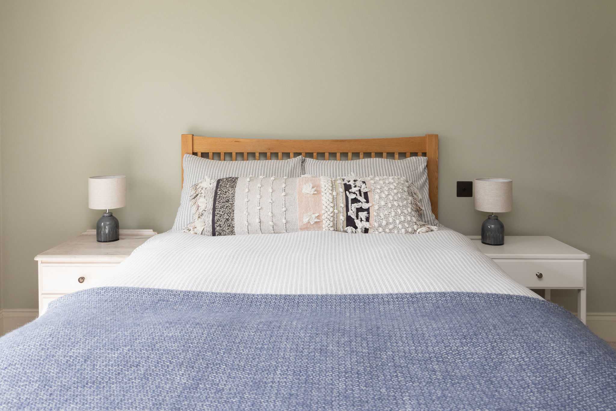 Comfortable and inviting with quality linens, patterned cushions, and a clean, modern style.