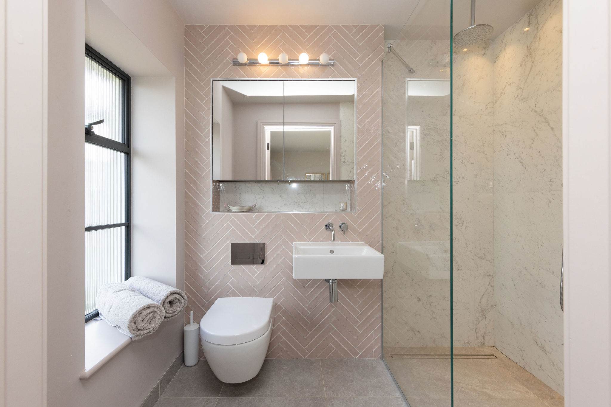 Beautifully tiled bathroom with walk-in shower, contemporary fixtures, and a sleek modern finish.