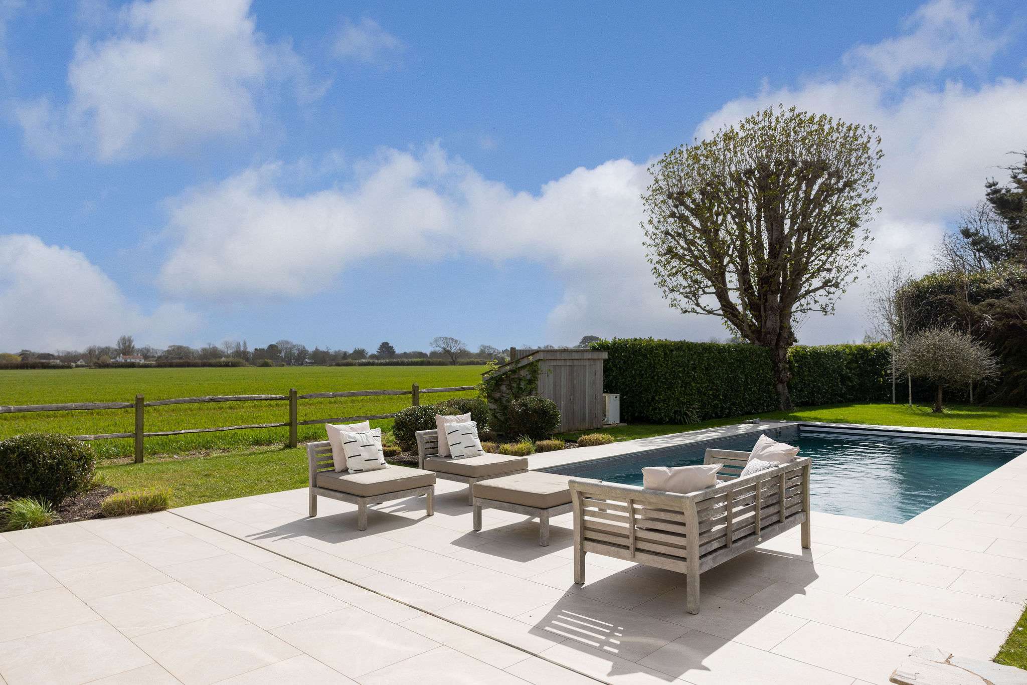 Heated pool surrounded by landscaped gardens and open countryside — perfect for summer relaxation.