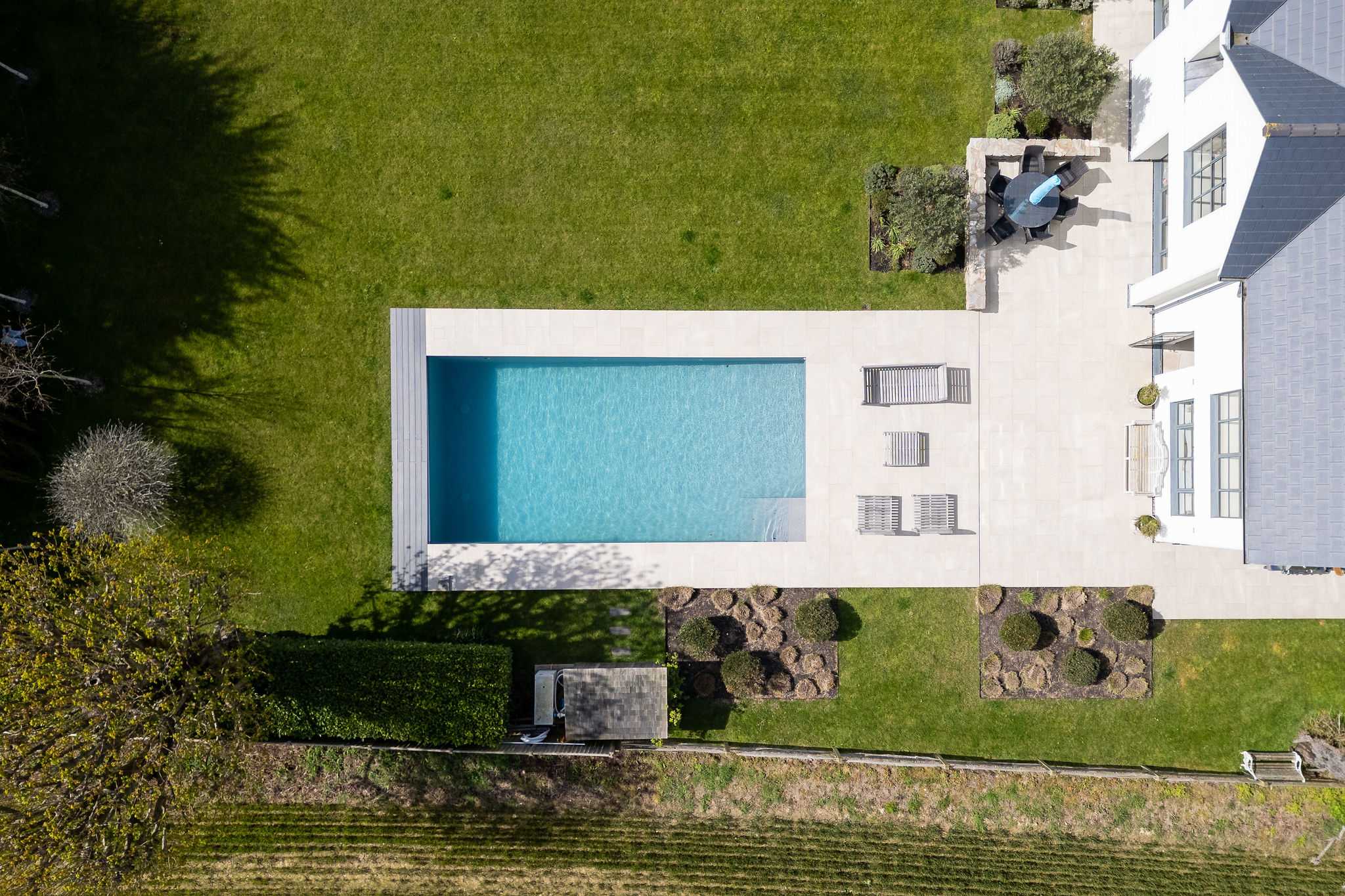 Bird's eye view of the heated pool nestled within beautifully landscaped gardens and mature planting.