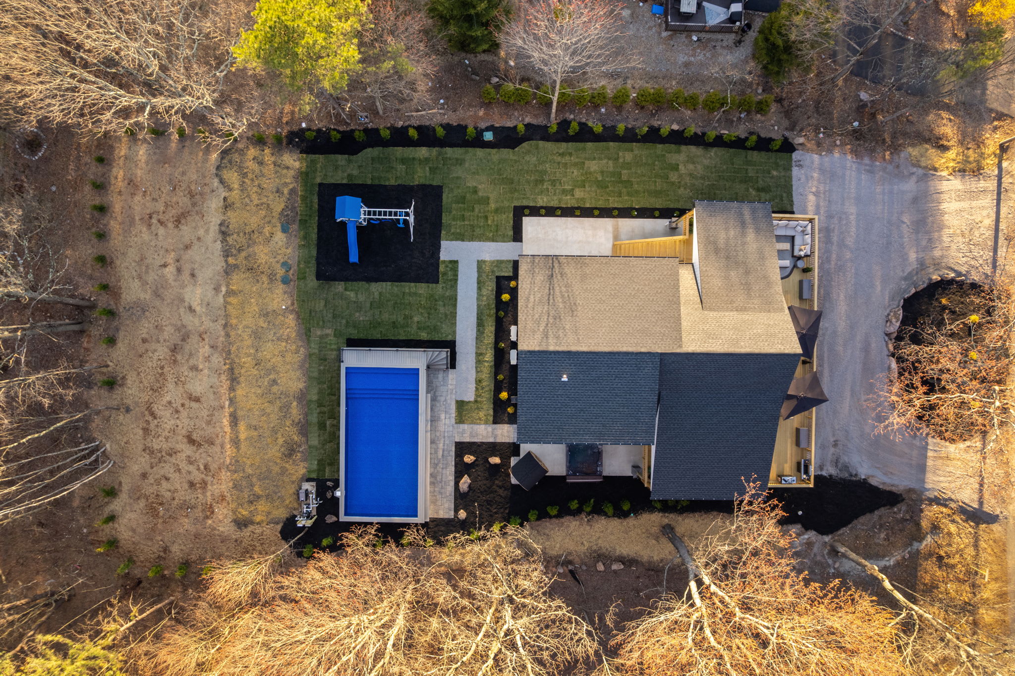 Bird's-eye view of the property with pool, swing set, and wraparound deck