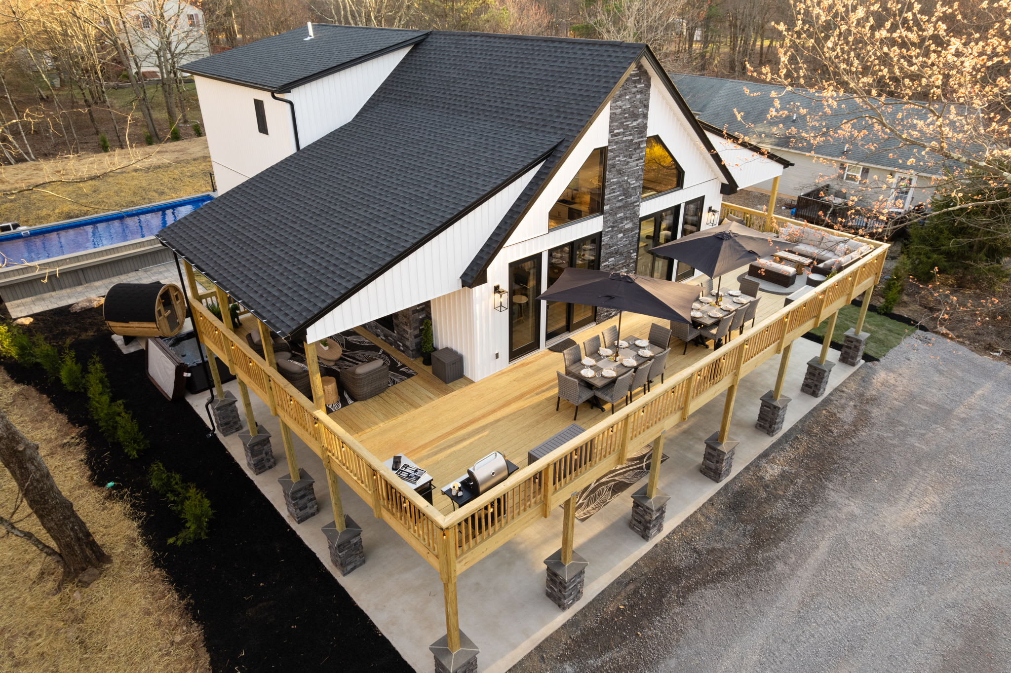 Aerial roofline view of the wraparound deck and pool surrounded by trees
