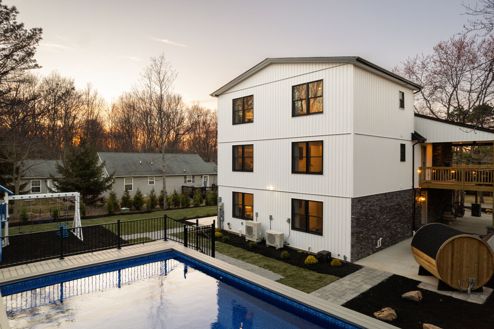 Front exterior with in-ground pool and mountain-modern board-and-batten architecture