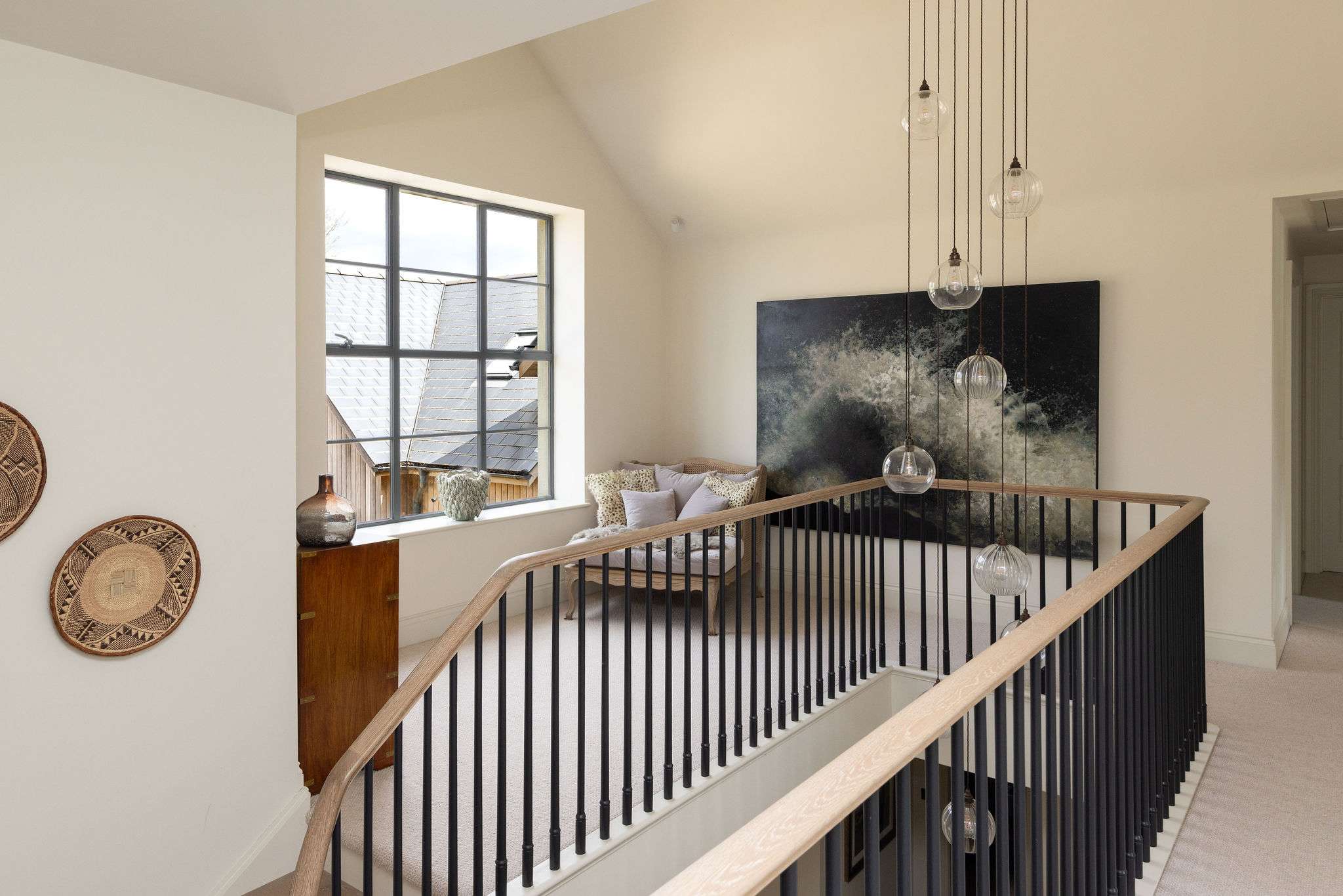 A curated landing with statement lighting and artful touches reflecting the home's exceptional design.