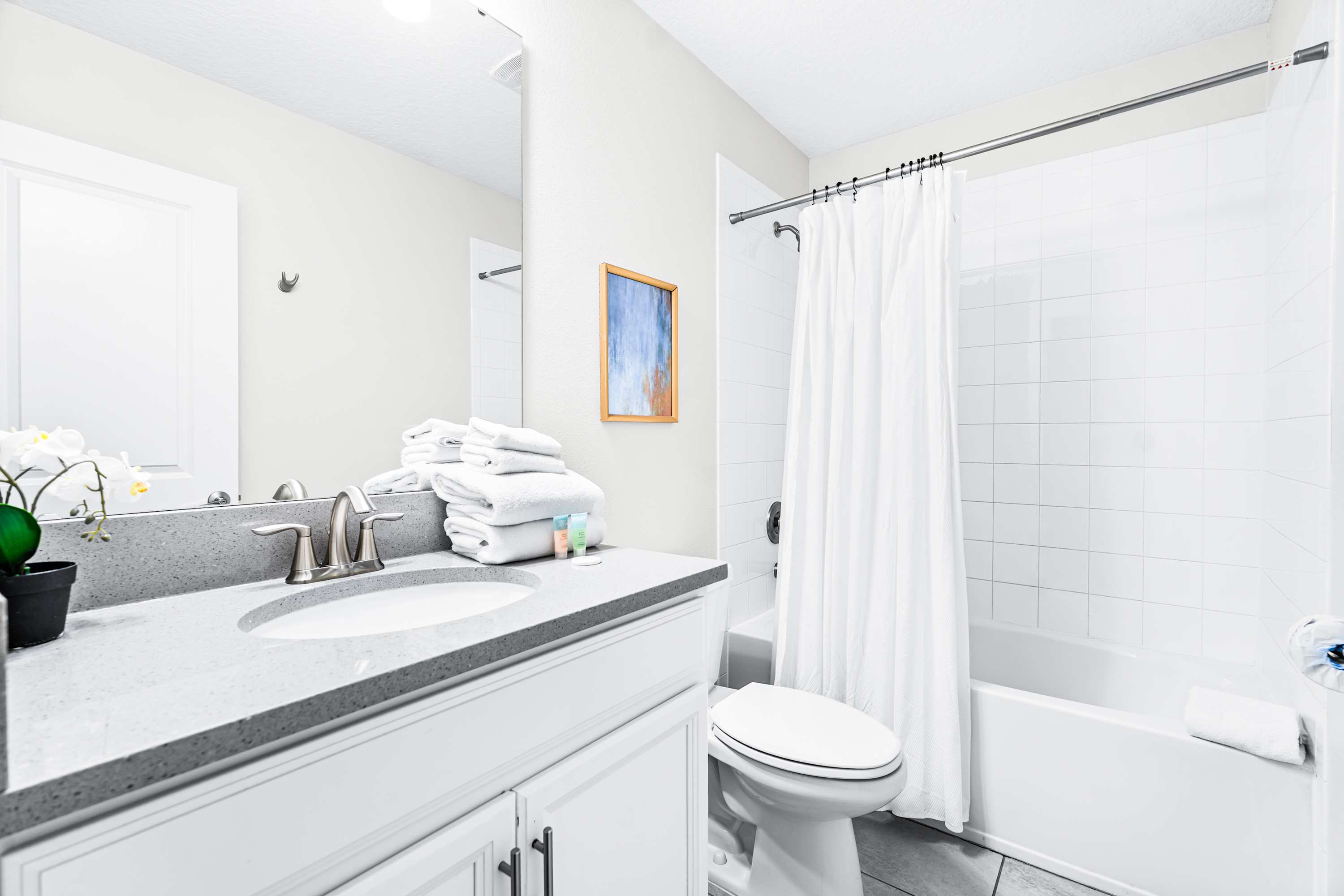 Bright and modern bathroom with clean finishes and ample lighting.