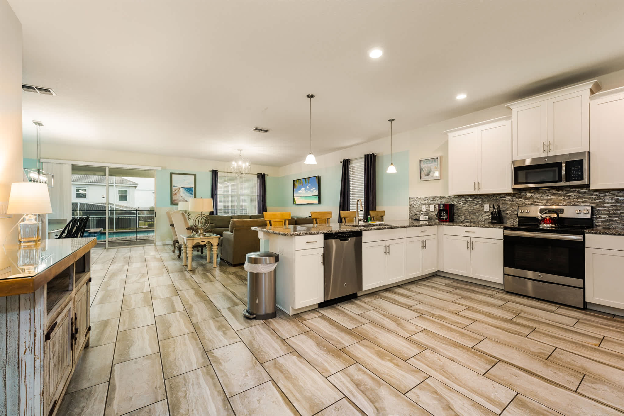 Modern open-plan kitchen and living area with ample seating, perfect for entertaining large groups.
