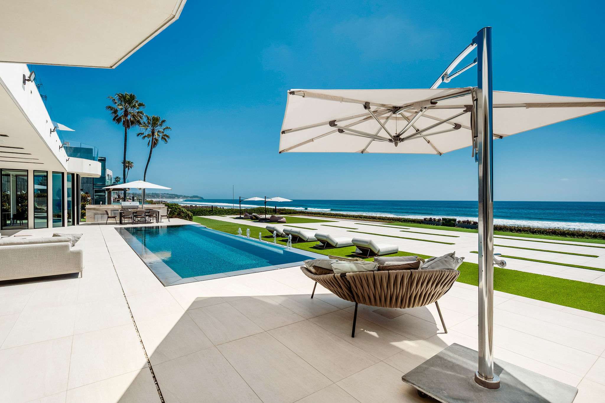Spend the day poolside under shade, with the oceanfront stretching out ahead.