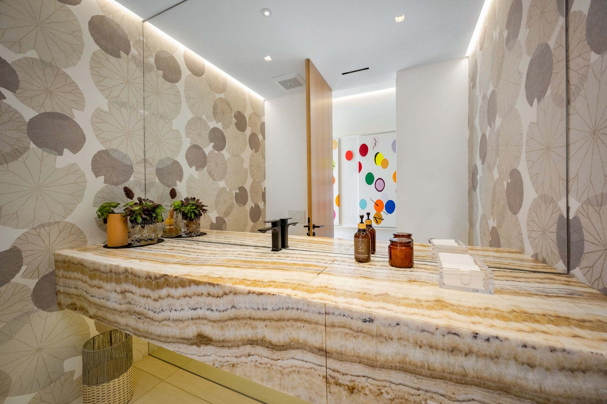 A floating vanity set against a statement wall within a spa-style bathroom.